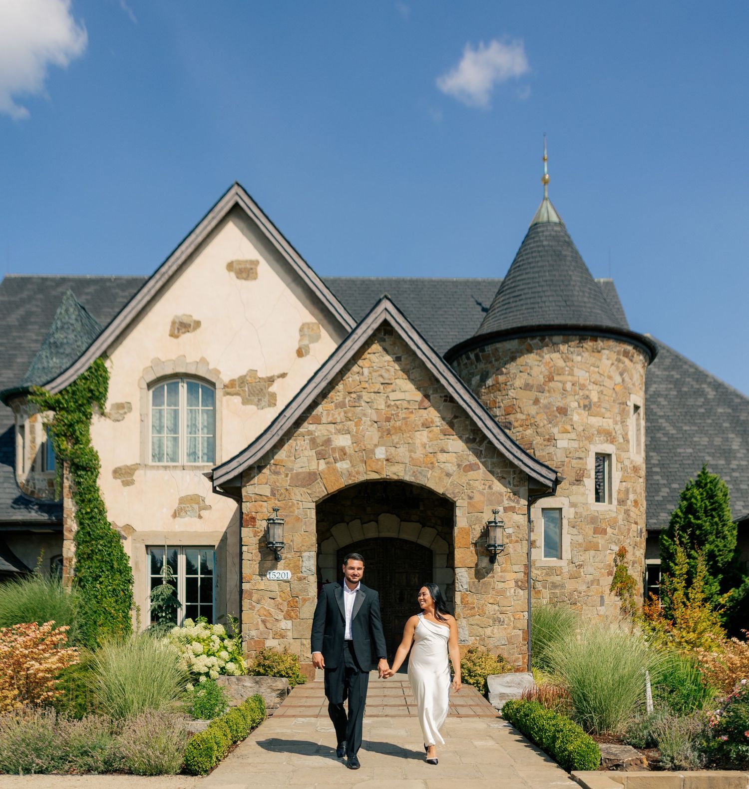 Stone and stucco wedding chapel entrance with garden pathway and mountain backdrop in the distance.