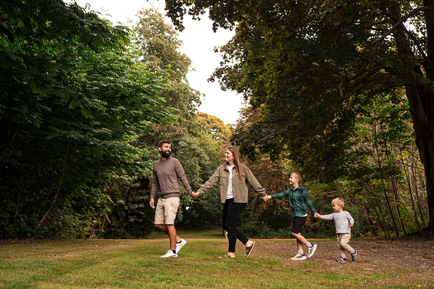 People playing and running together in a park on a sunny autumn day with trees in the background.