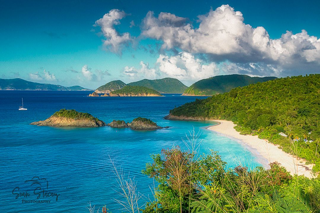 Stunning aerial view of Trunk Bay beach in St. John with turquoise waters, white sand and lush green hills.