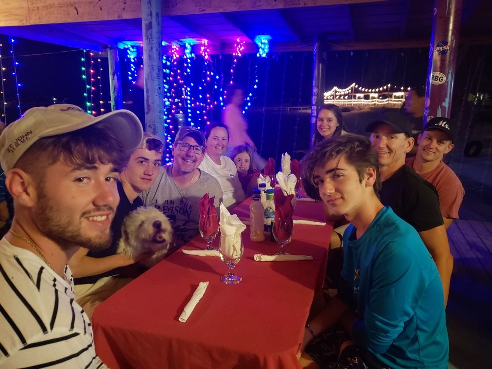 Dinner with friends in dim blue light — British Virgin Island community and laughter.