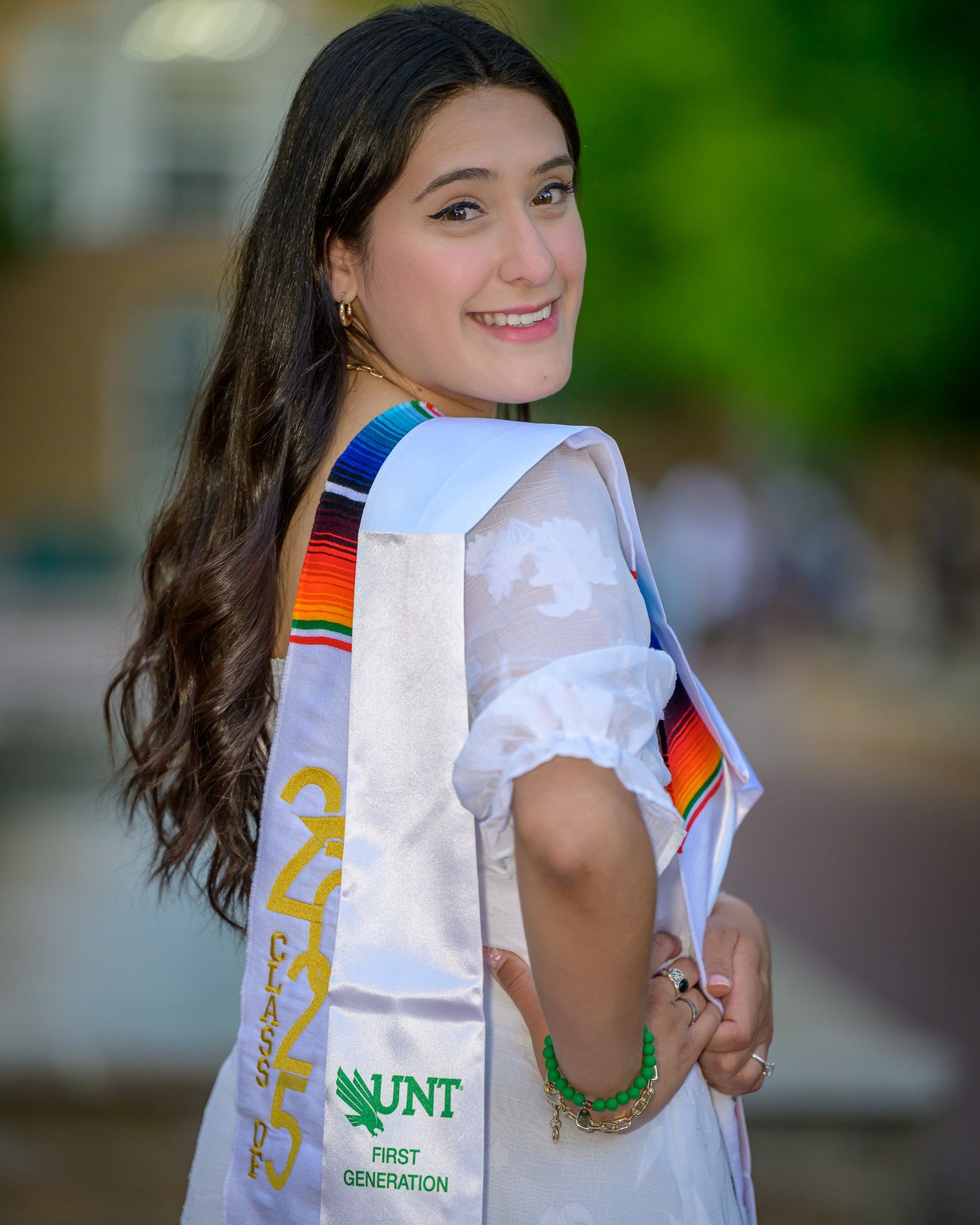 A series of graduation photos featuring someone in white attire with a university branded bag.