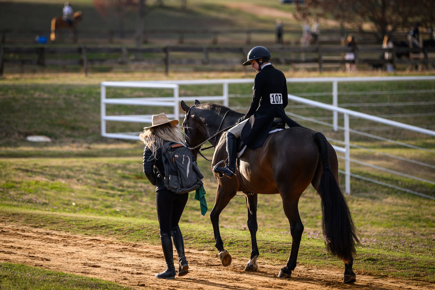 Trainer and rider discussing strategy ringside at a horse show