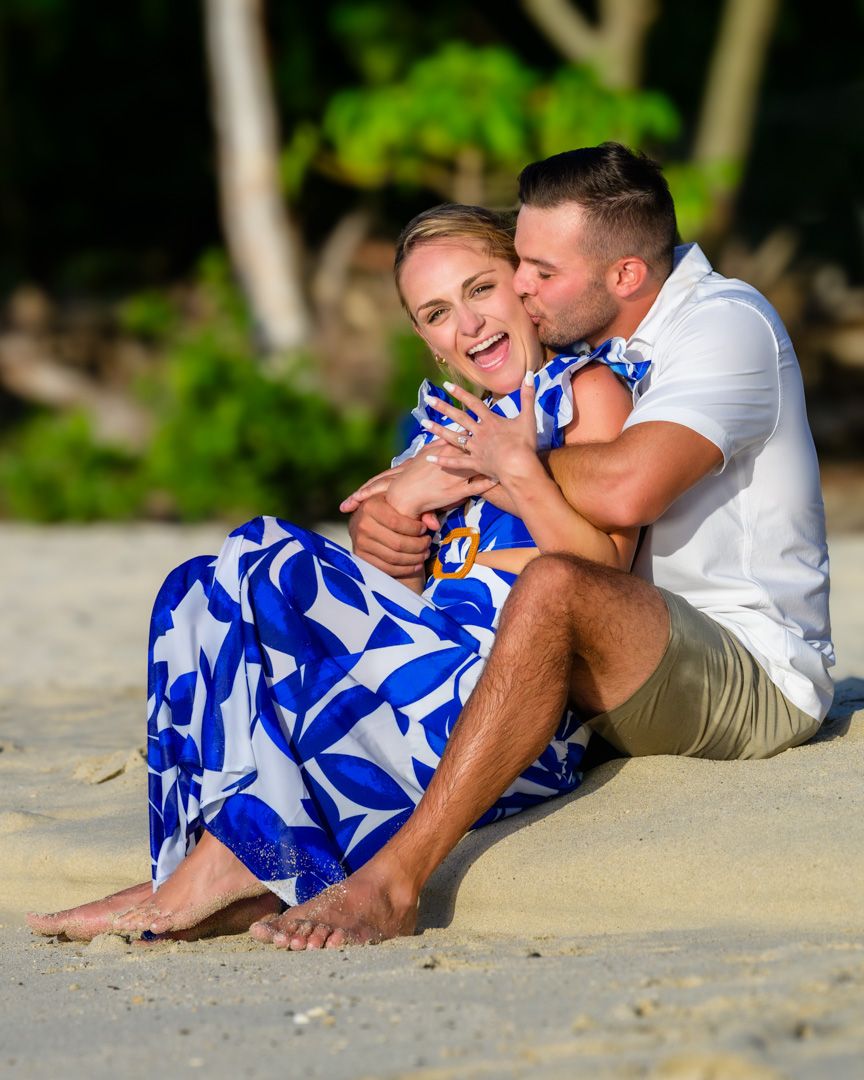 A couple in blue and white attire shares a romantic moment after a wedding proposal photographed by Sean Stacey Photography.