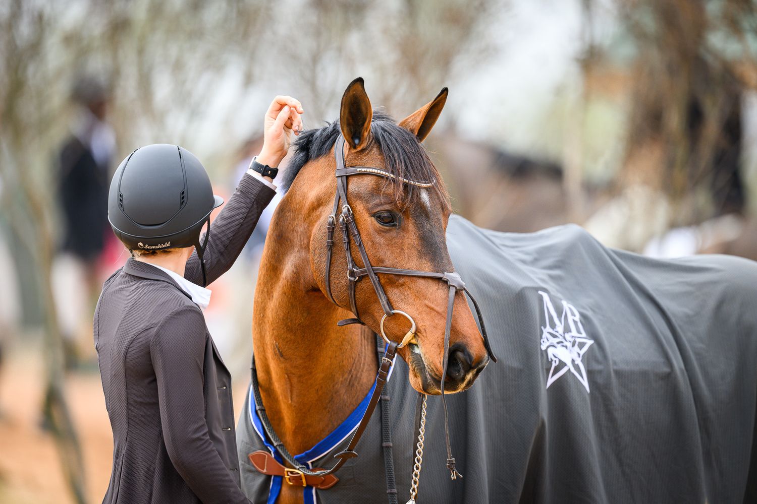 Close-up of rider embracing her horse after a memorable competition round