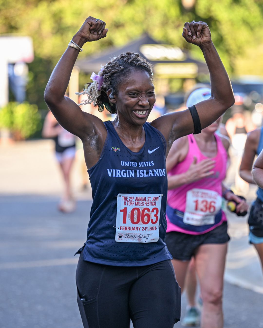 Enthusiastic runners celebrate with raised arms during a the 8 Tuff Miles race on St. John, USVI as captured by photographer, Sean Stacey.