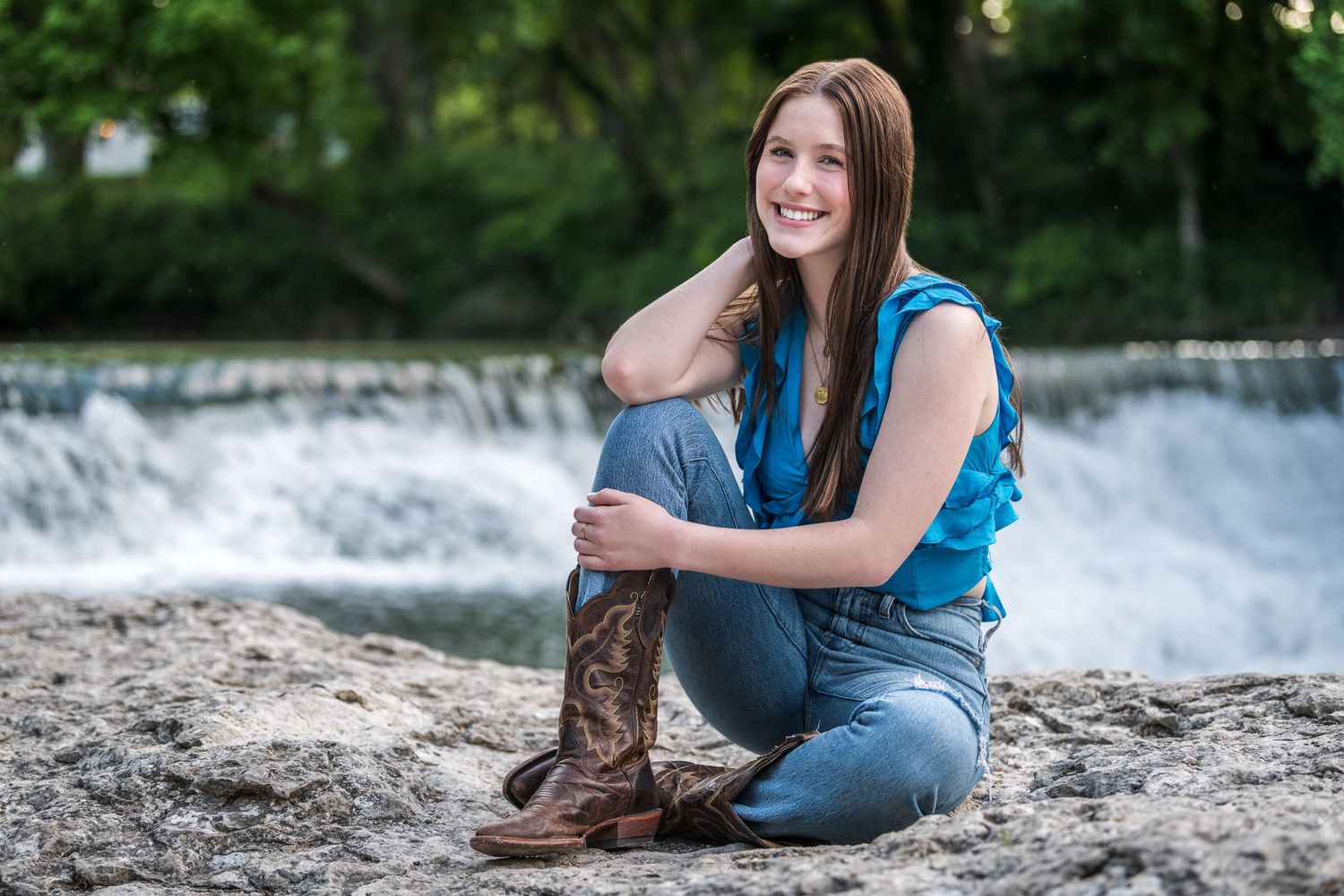 Senior girl portraits captured near a flowing waterfall with natural scenery in the background in Trinity Park, Ft. Worth, TX.