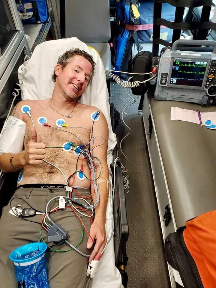 Medical monitoring equipment and sensors attached to a patient resting in a hospital bed.