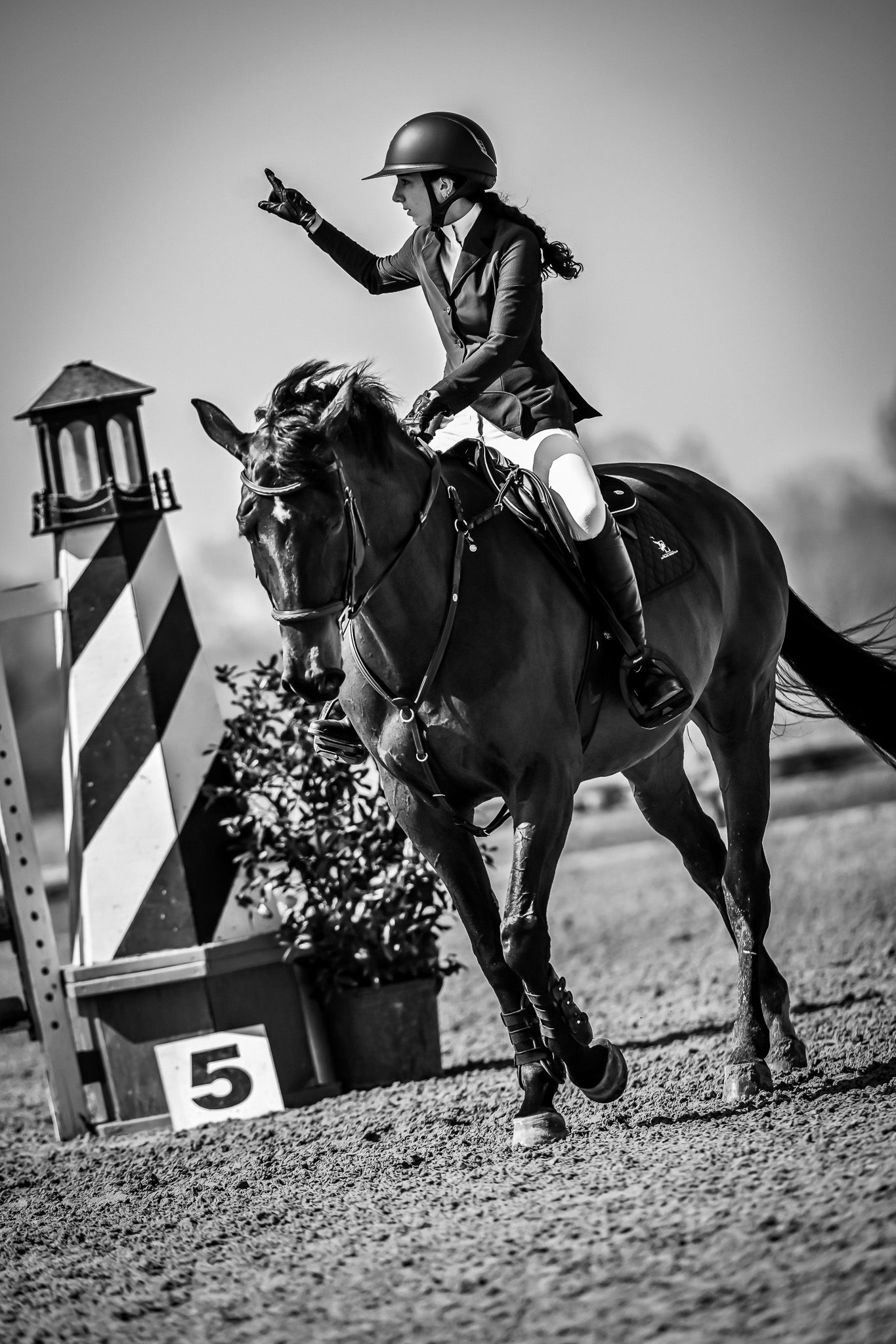 black and white photo of an equestrian girl preparing for a jumping course at Texas Rose Horse Park as captured by equine photographer Sean
