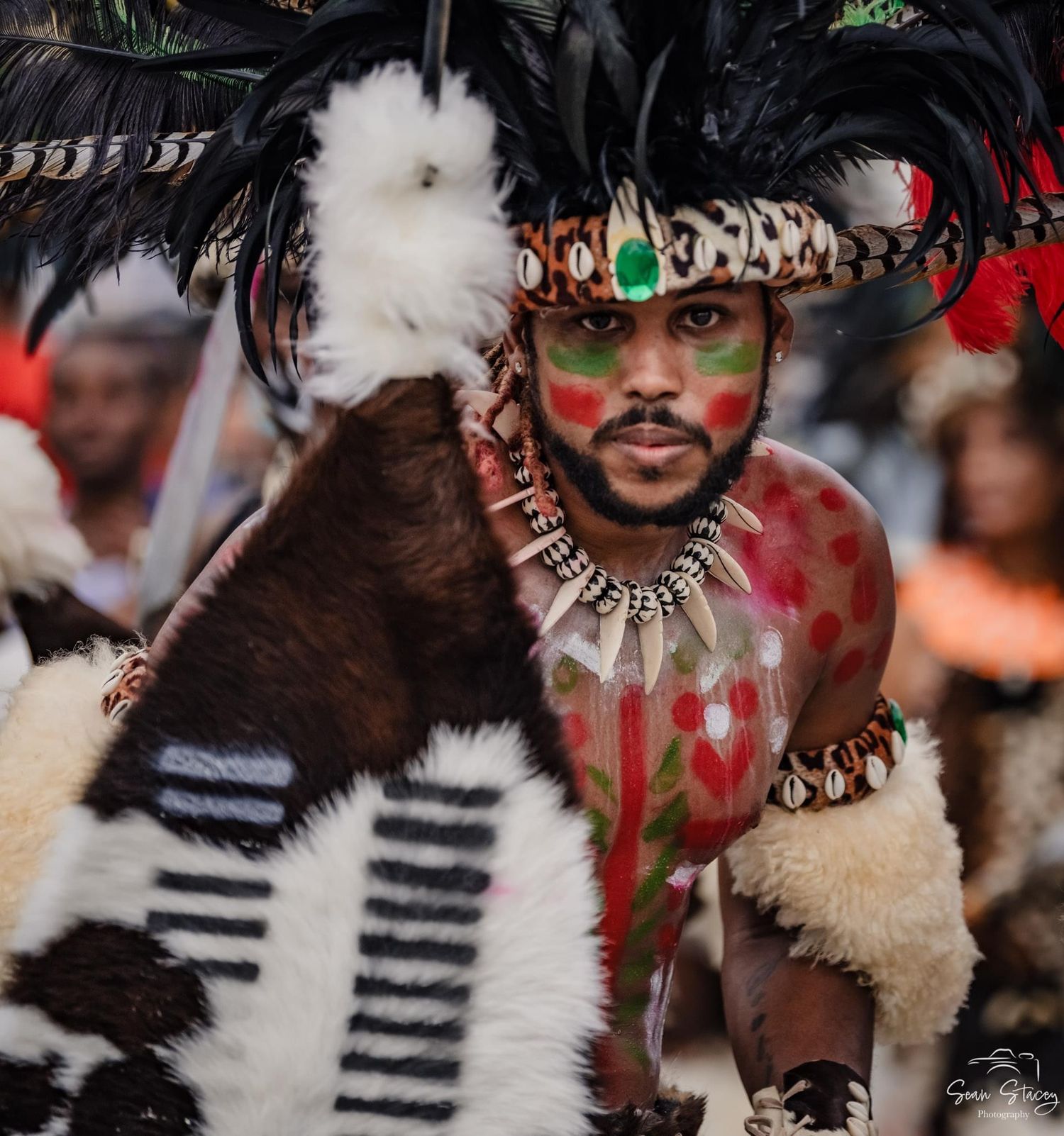 Dancers in tribal costumes with face paint and feathers perform at St. John Carnival in 2023.