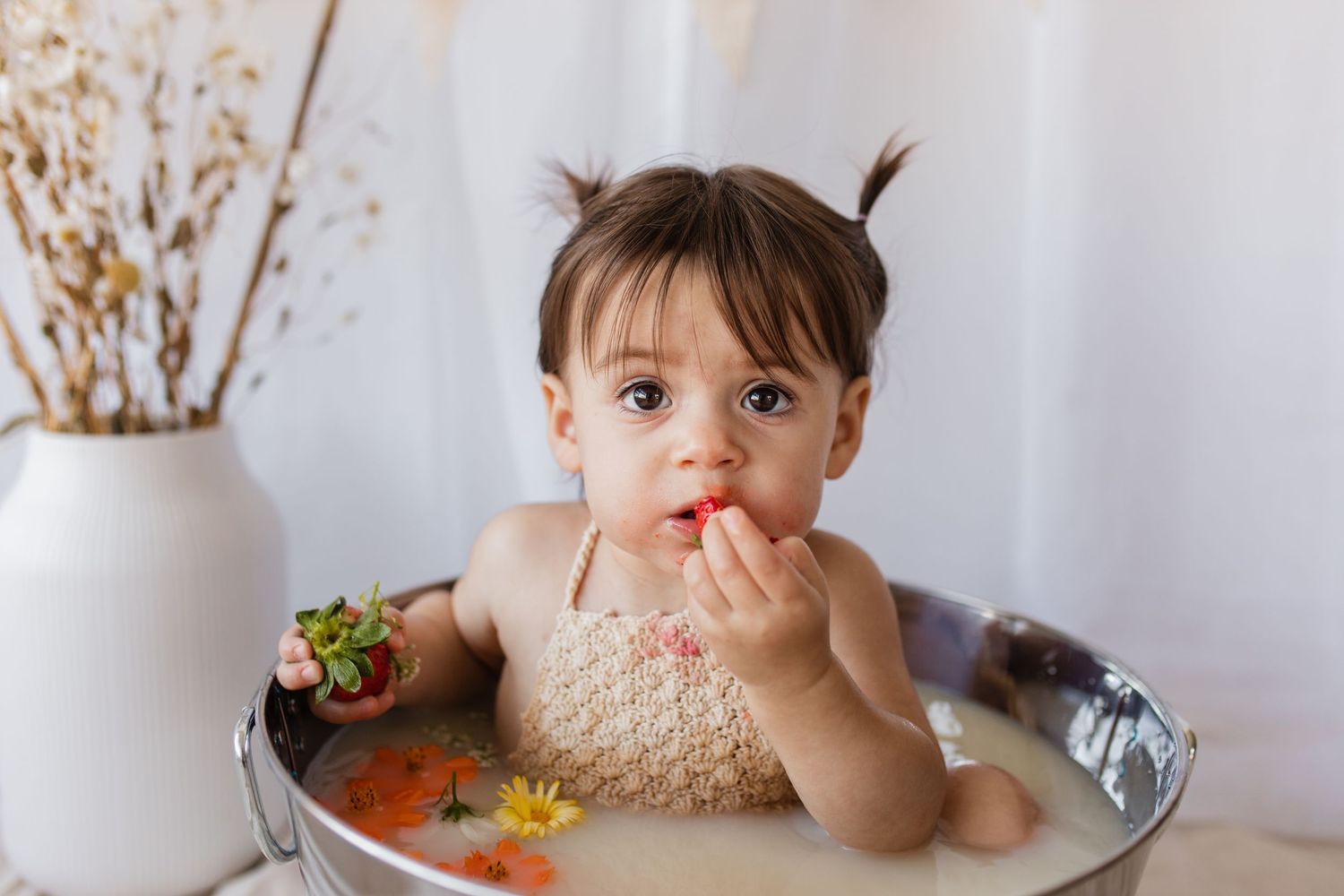 Rustic photoshoot setup with metal tub and floral decorations.
