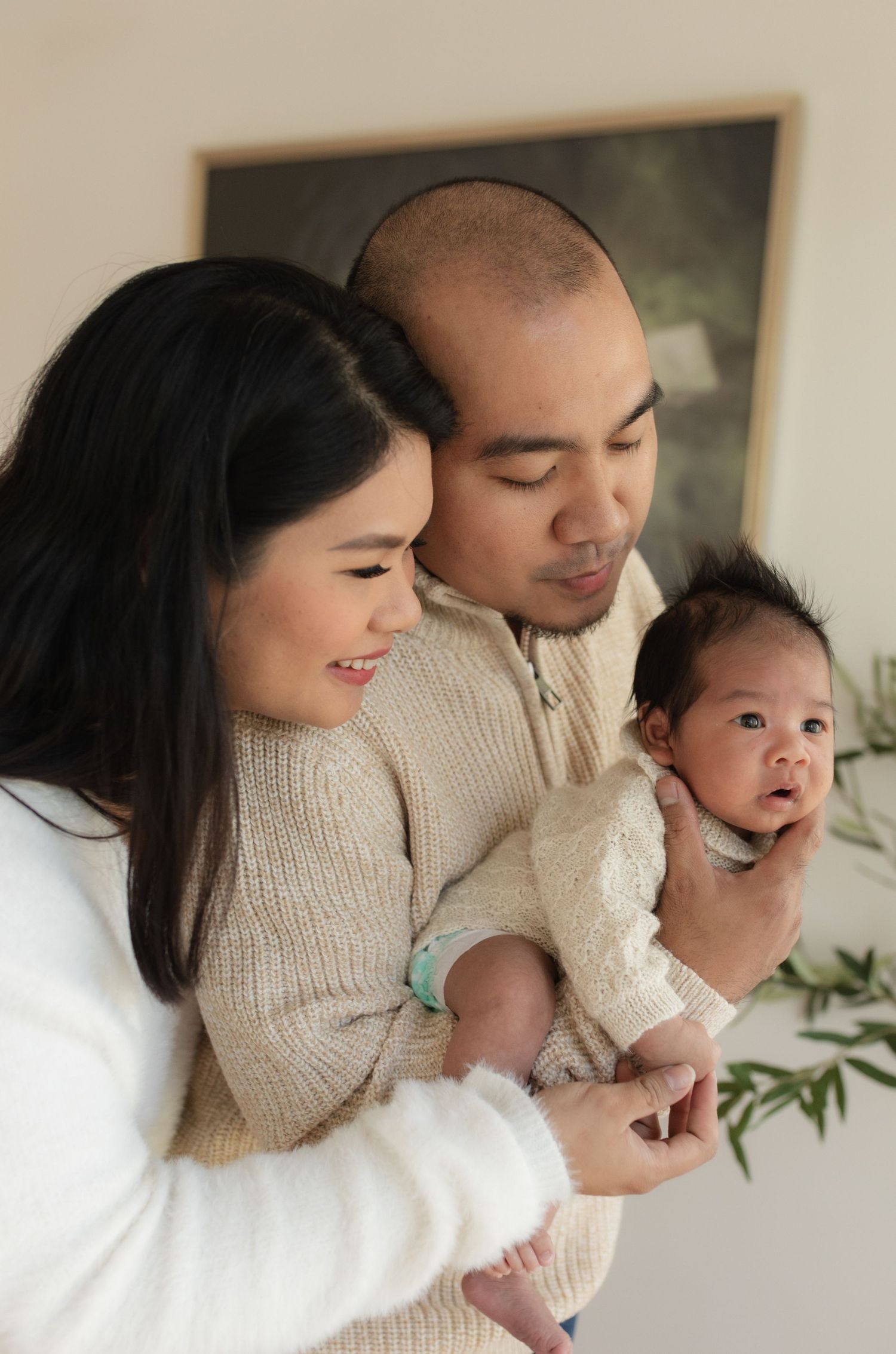 A tender family moment captured with a baby in a cozy cream knit sweater.
