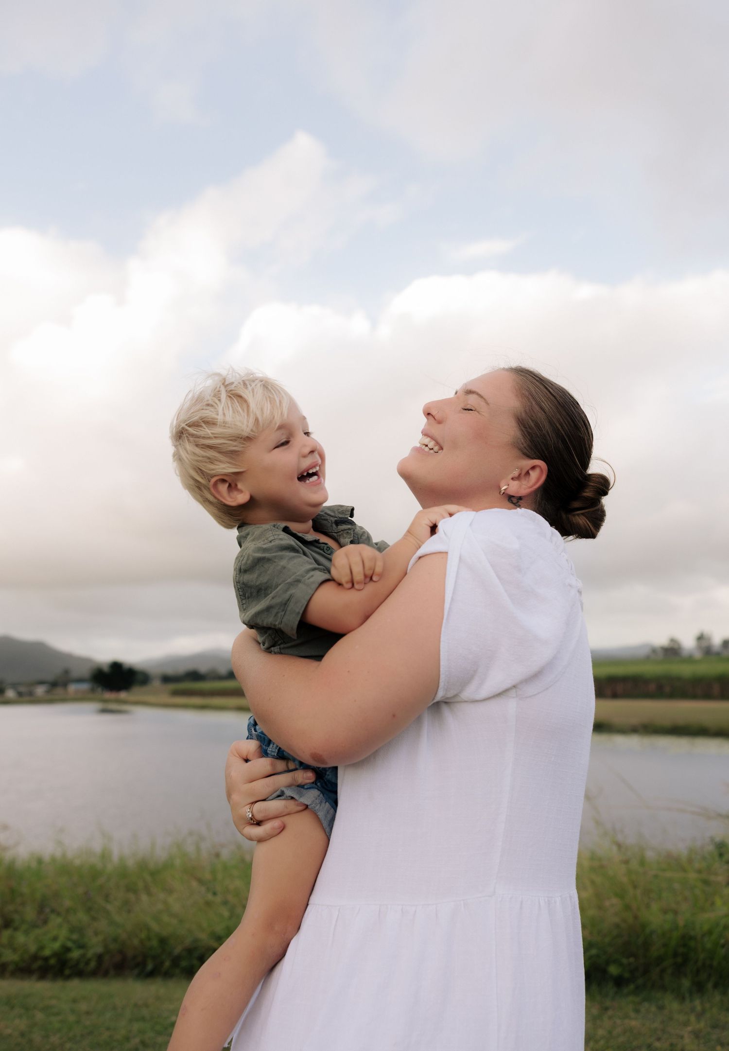 Joyful outdoor moment between parent and child by a peaceful lake.