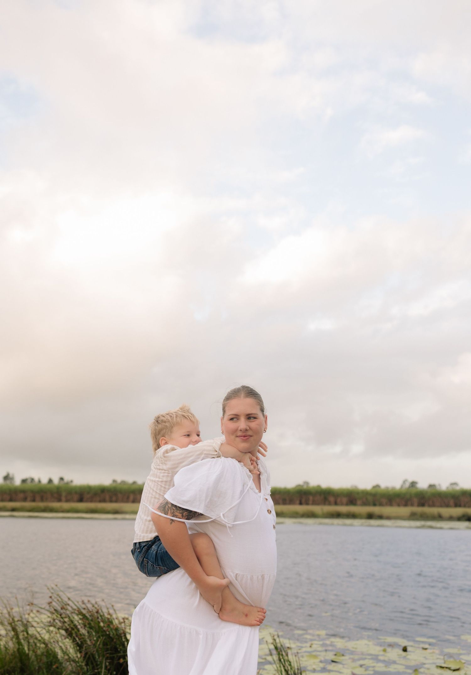 A tender moment captured between parent and child by a tranquil lake.