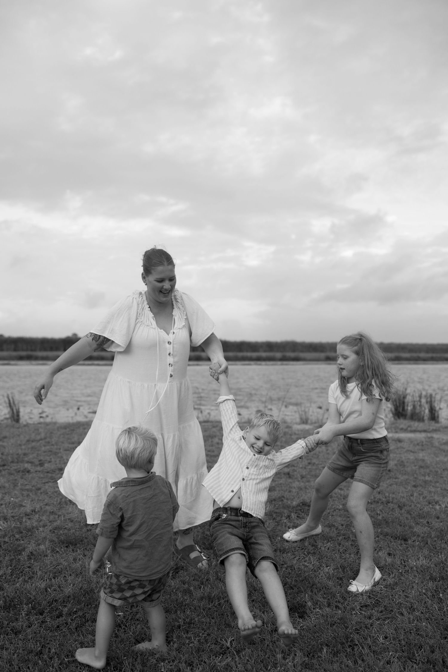 A playful black and white photo of a family enjoying time together outdoors.