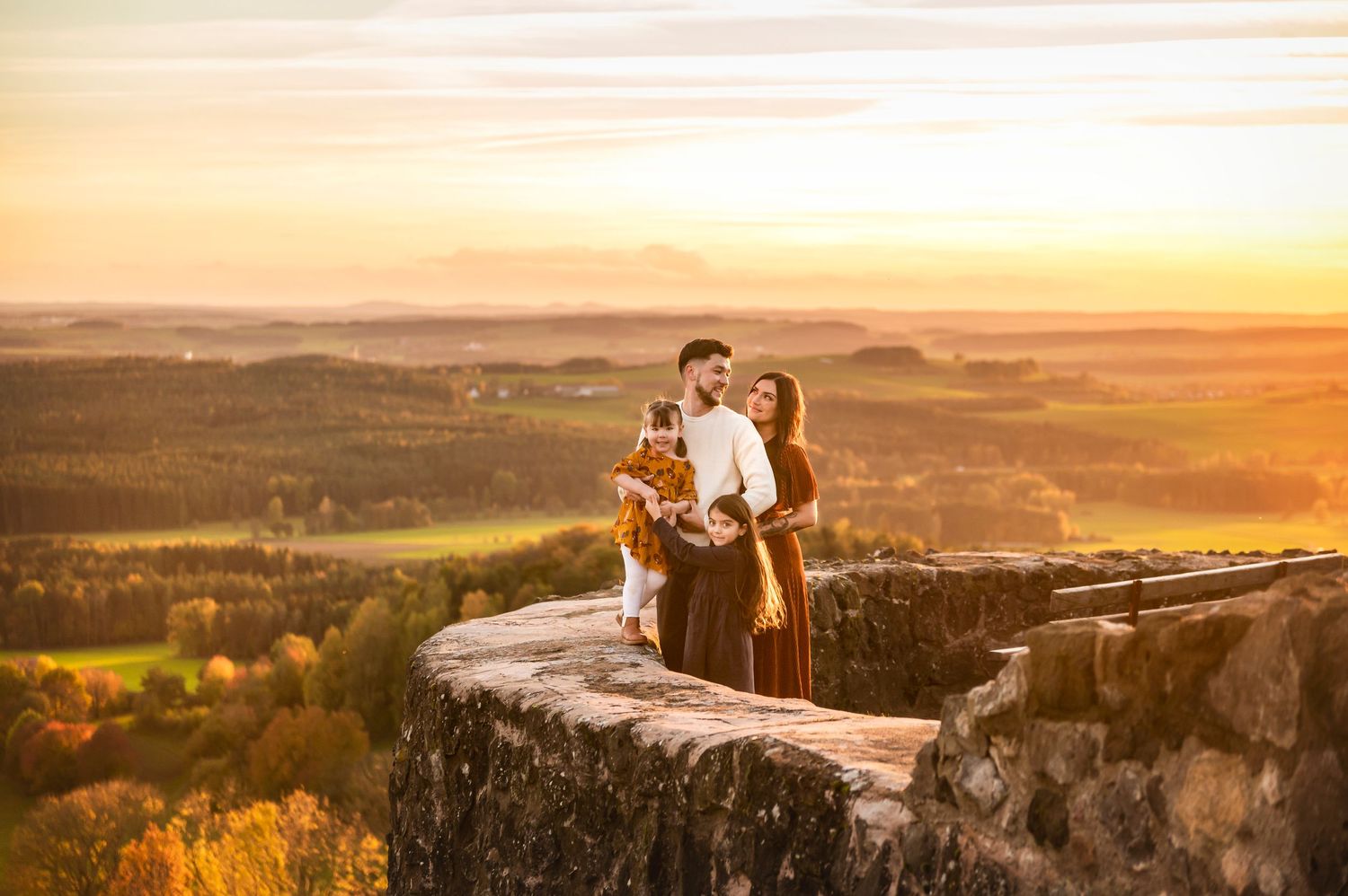 A golden sunset engagement photoshoot on dramatic clifftop overlook.