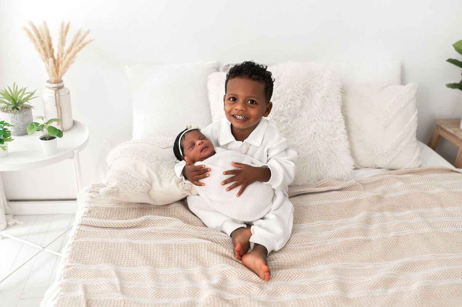 A peaceful scene with cream bedding and dried pampas grass decor in a bright bedroom.