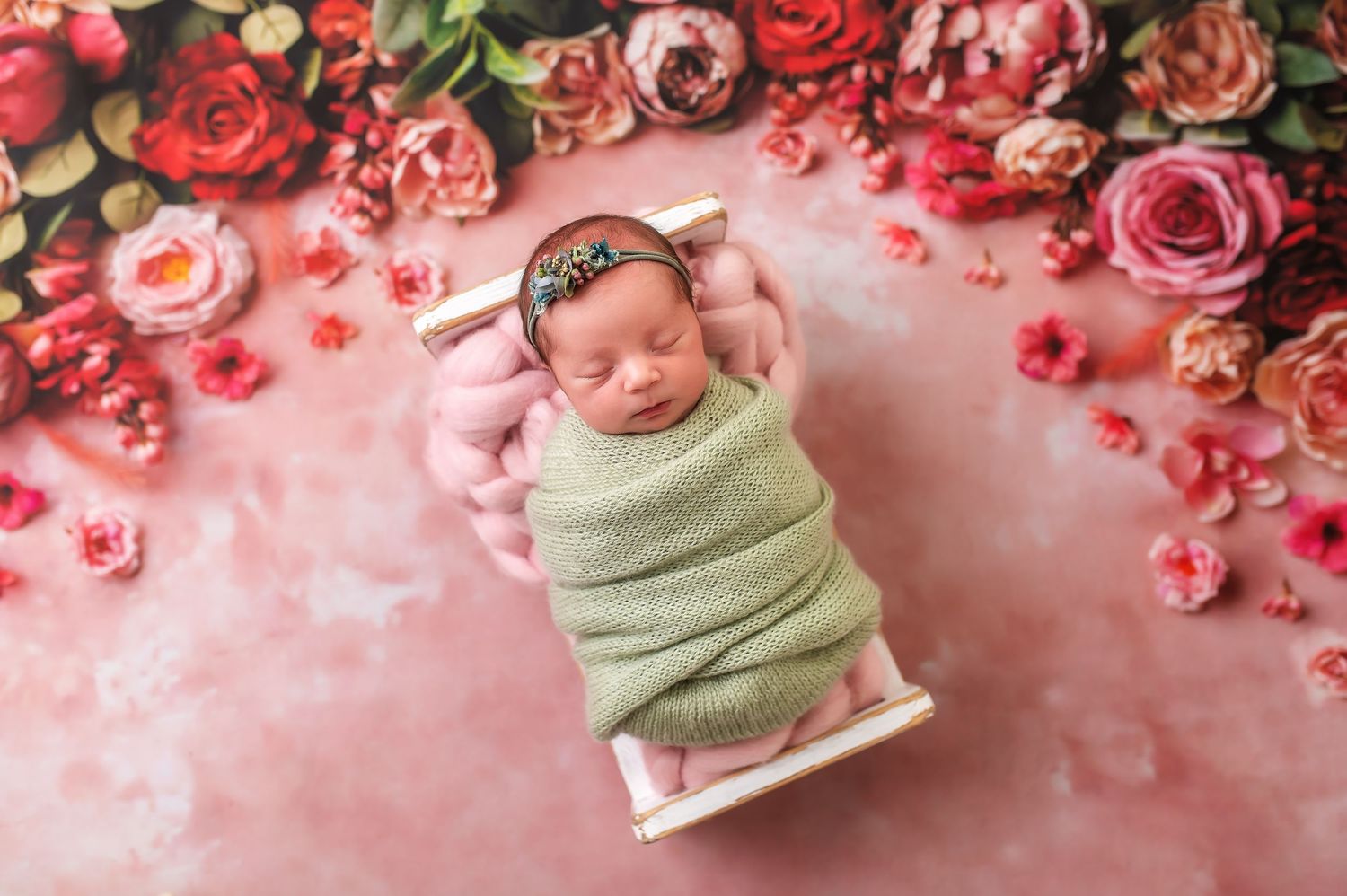 Floral backdrop with red and pink roses arranged against pink background.