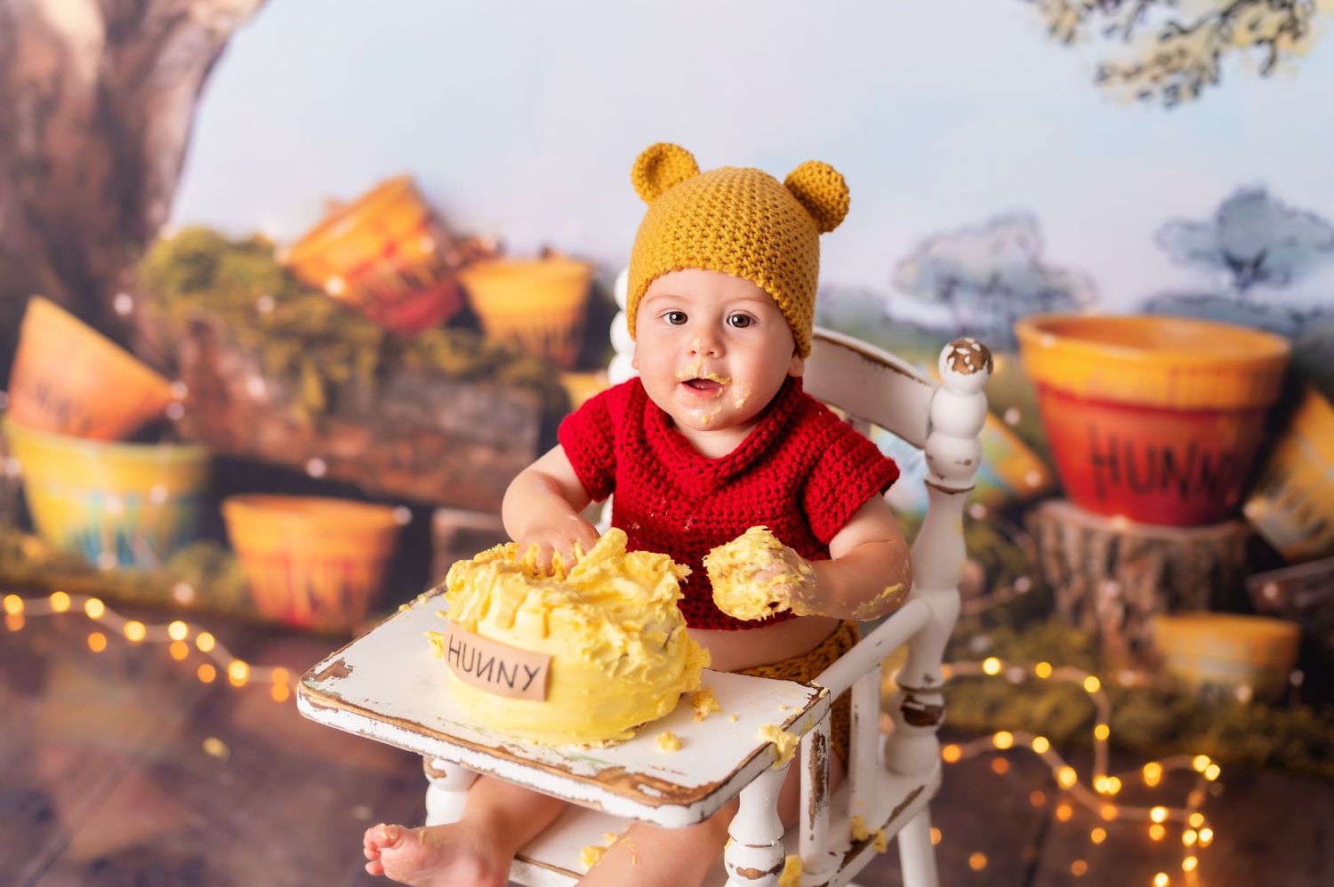 Autumn cake smash photography setup with pumpkins and twinkling lights.