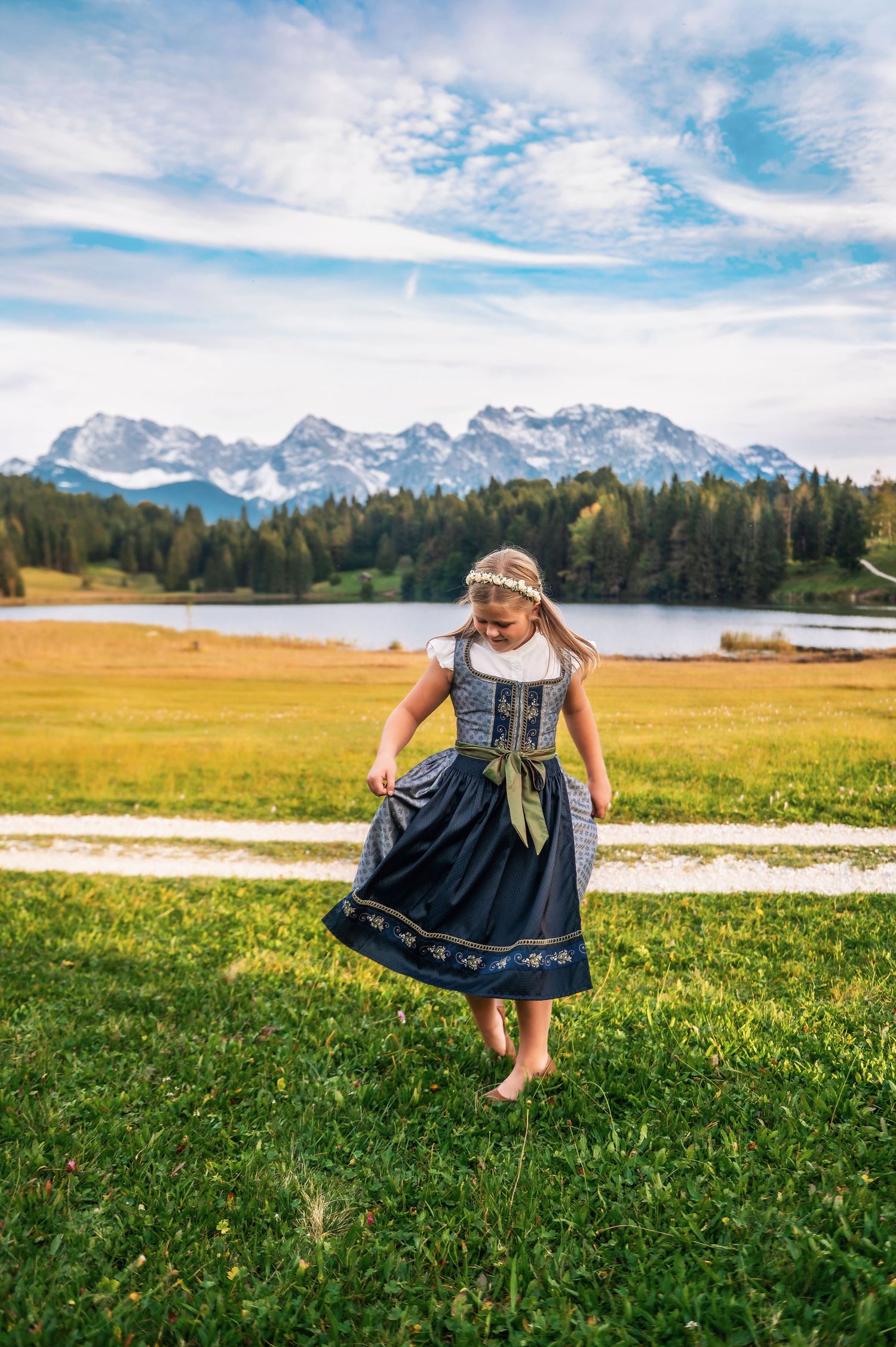Scenic alpine lake surrounded by mountains with grassy meadow and forest in Bavaria, Germany.
