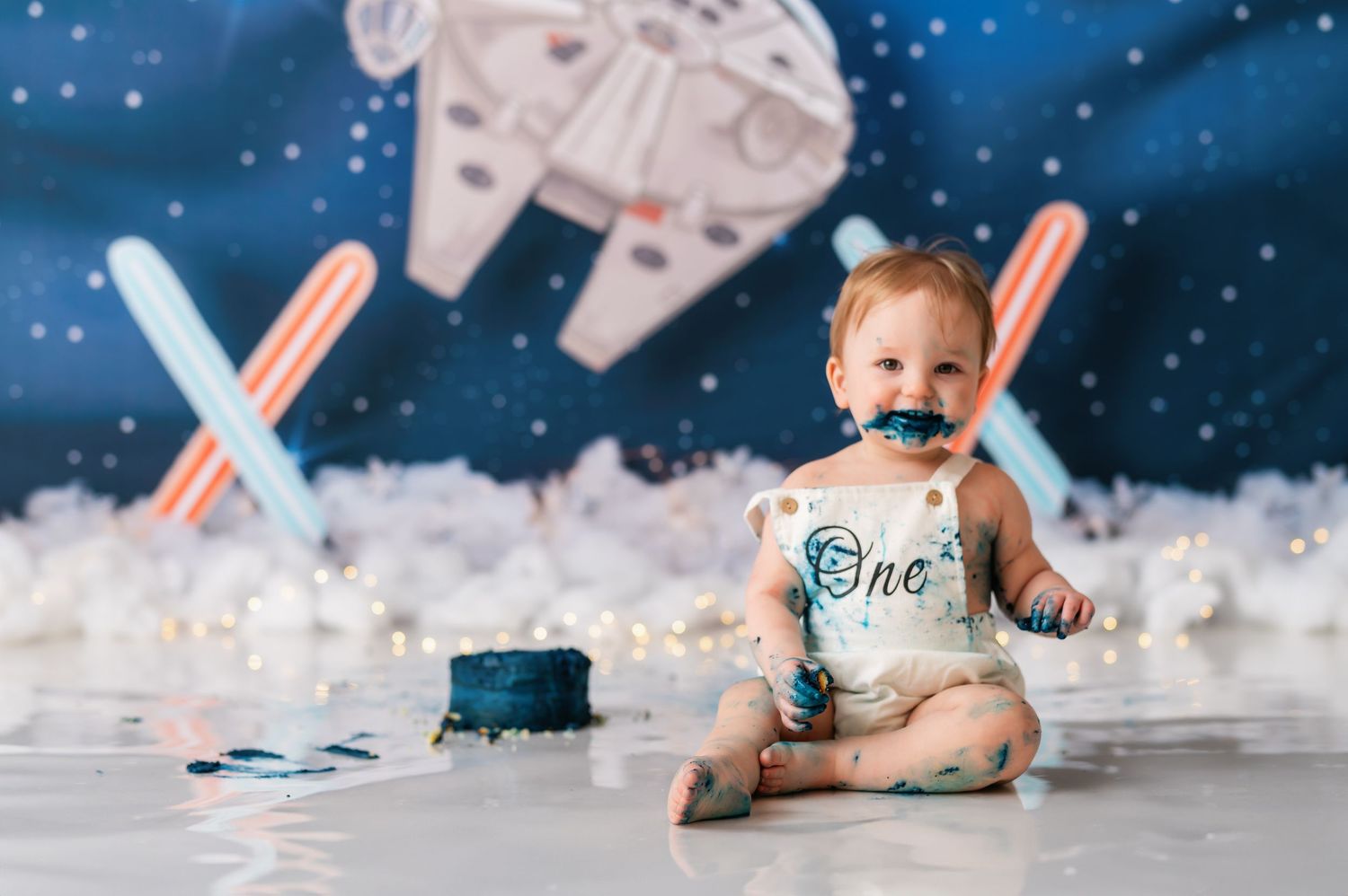 Star Wars inspired cake smash photo setup with dramatic lighting and space decorations.