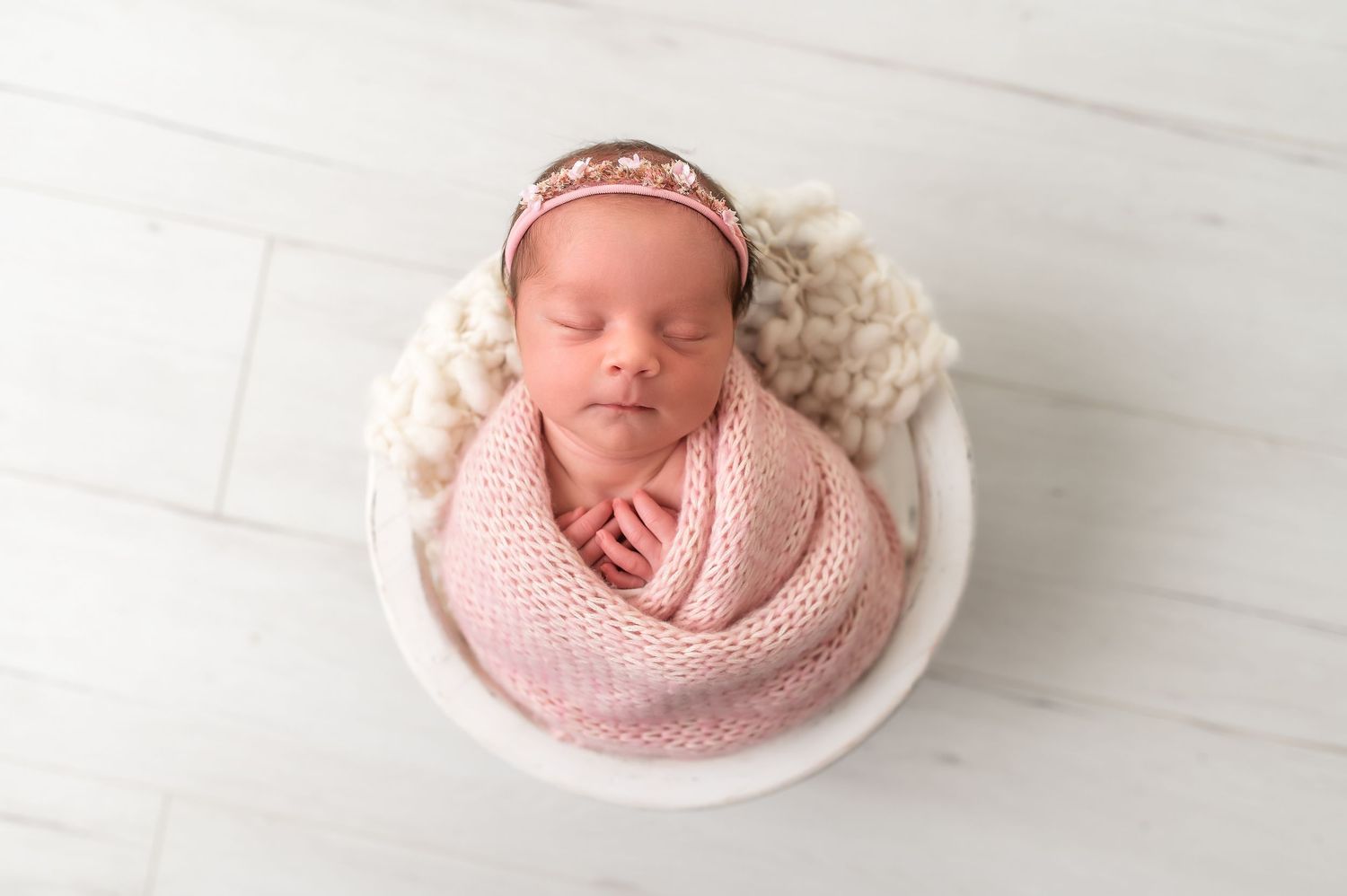 Collection of newborn photography setups with pink wraps and floral accessories.