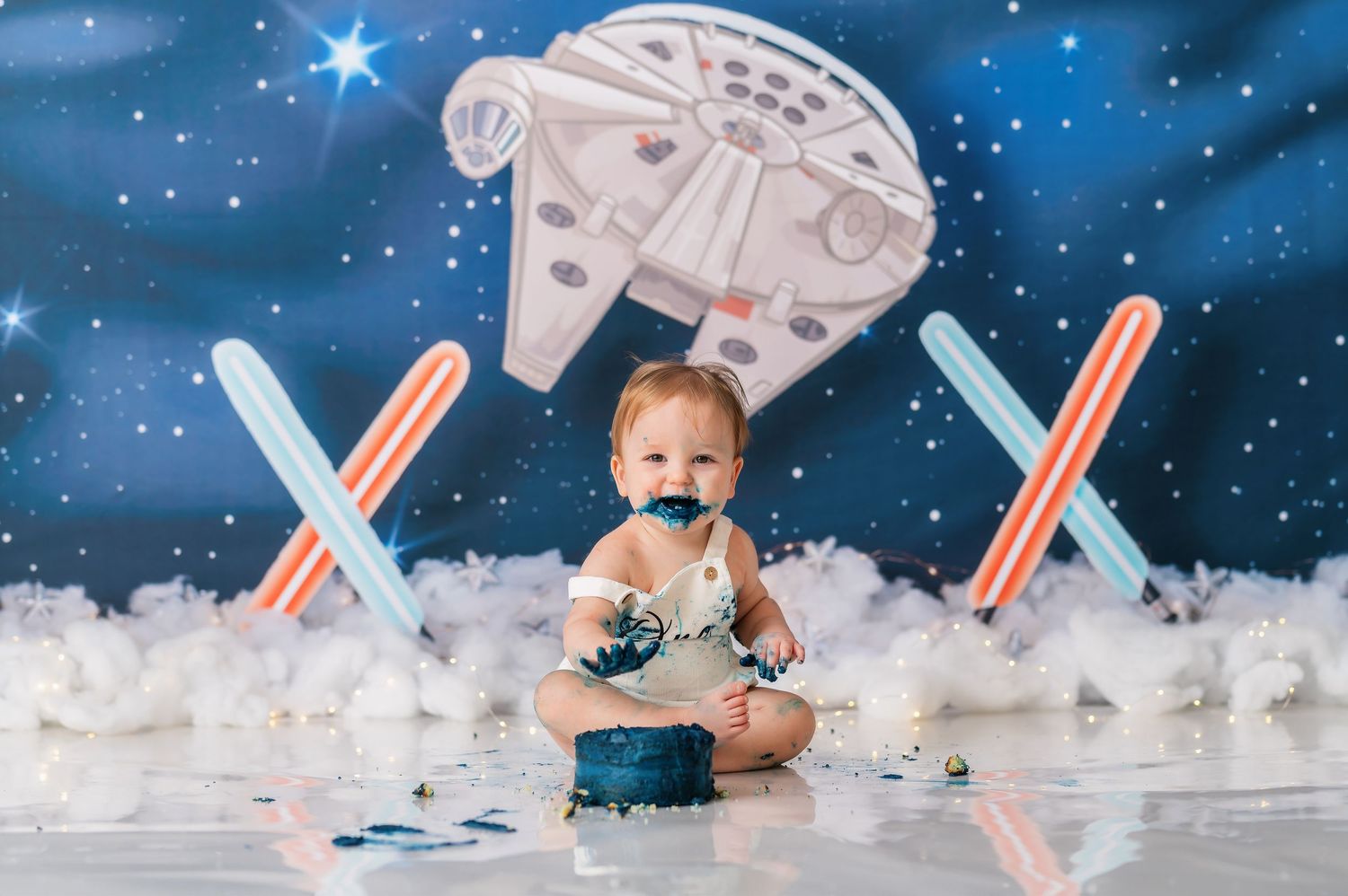 Star Wars themed cake smash photoshoot setup with Millennium Falcon and lightsabers.