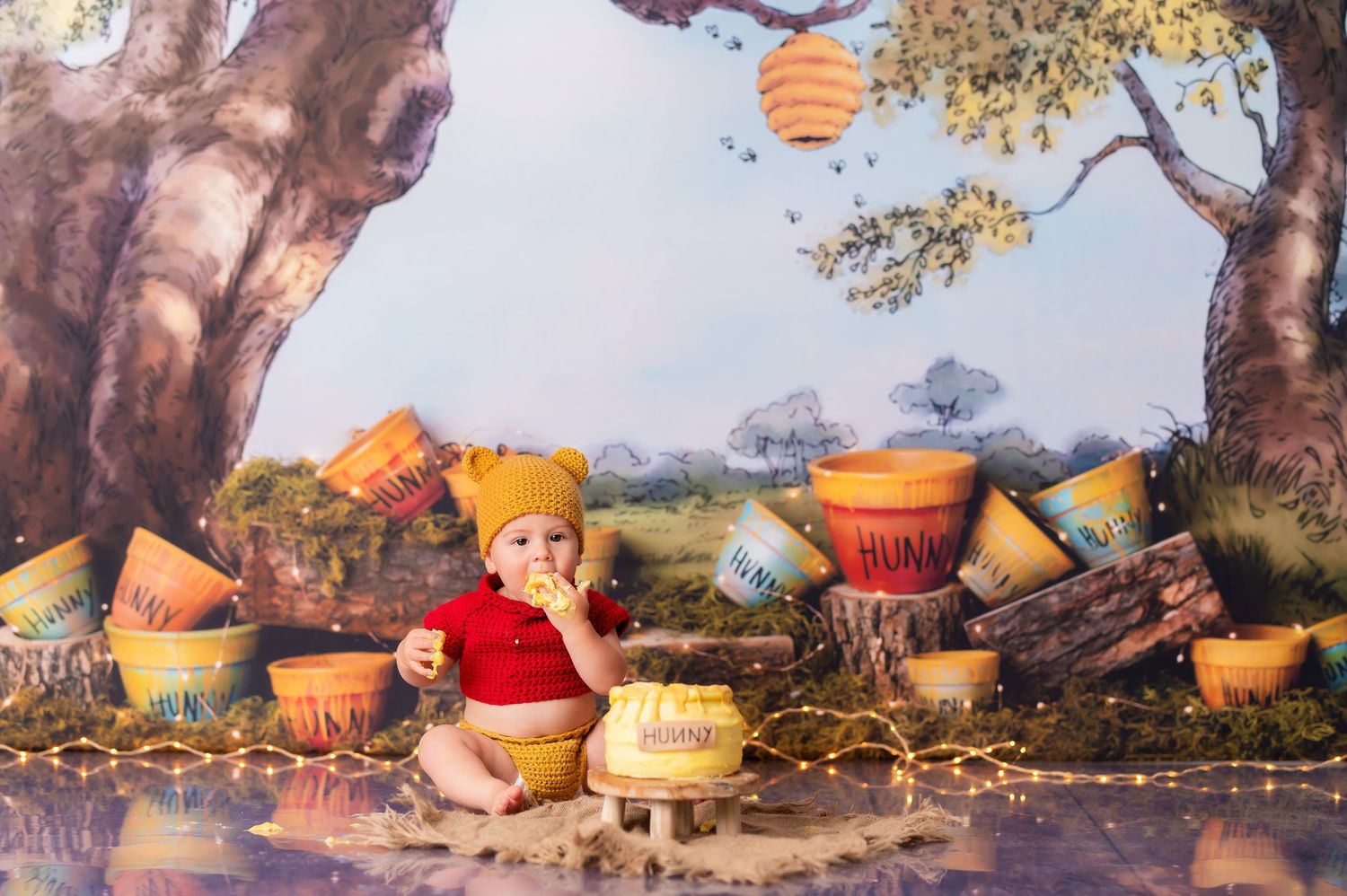 Whimsical autumn themed photography setup with pumpkins and twinkle lights under tree branches.
