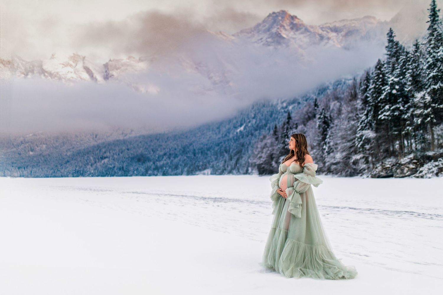A scenic winter photo shoot in the snowy mountains with ethereal green dresses against the pristine white landscape.
