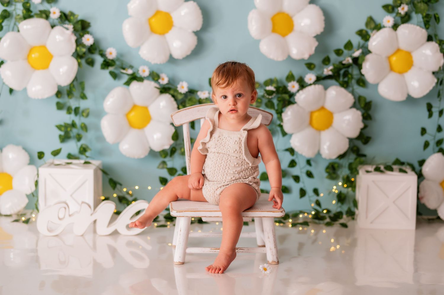 Floral backdrop with white daisies and green vines for baby photography.