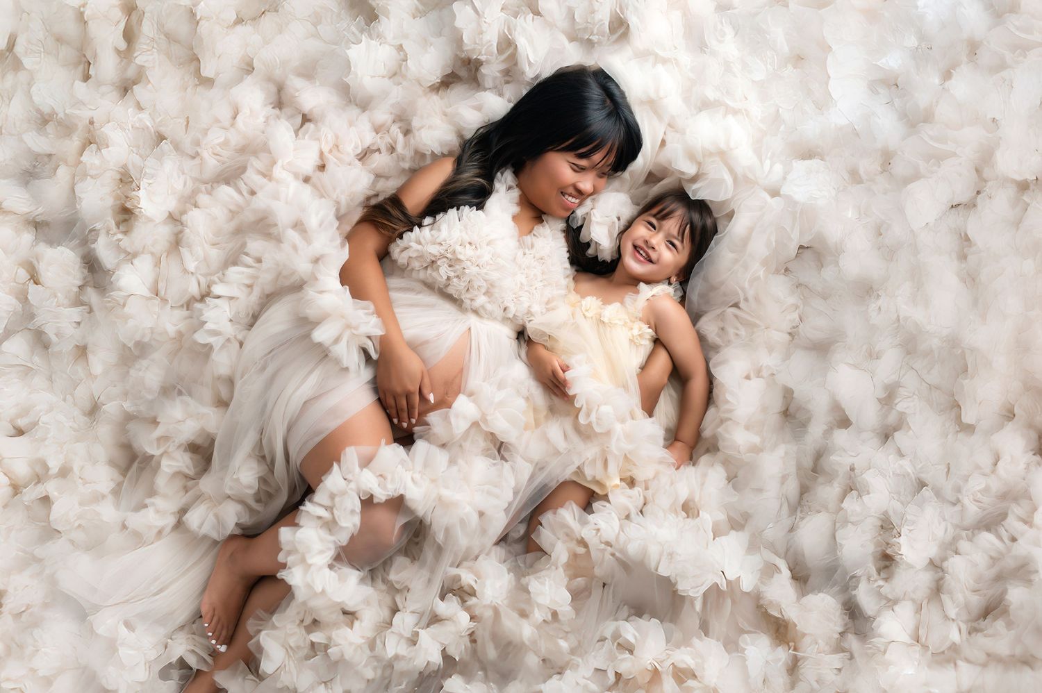 Four artistic photos show someone laying in white flowers and petals creating an ethereal and dreamy effect.