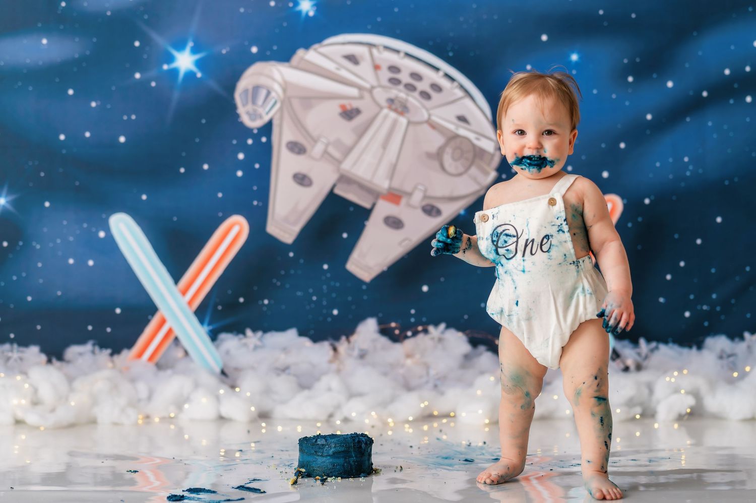 Star Wars themed birthday photo session with spaceship props and fluffy white clouds.