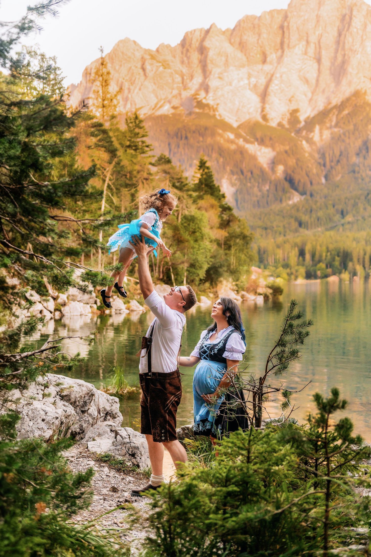 A group enjoys a scenic mountain adventure by a pristine alpine lake surrounded by towering rocky peaks and evergreen trees.