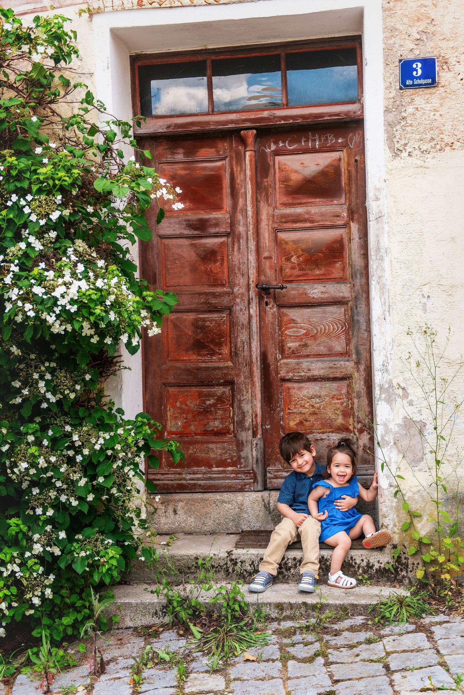 Series of candid photos of people relaxing against rustic wooden doors with flowering vines.