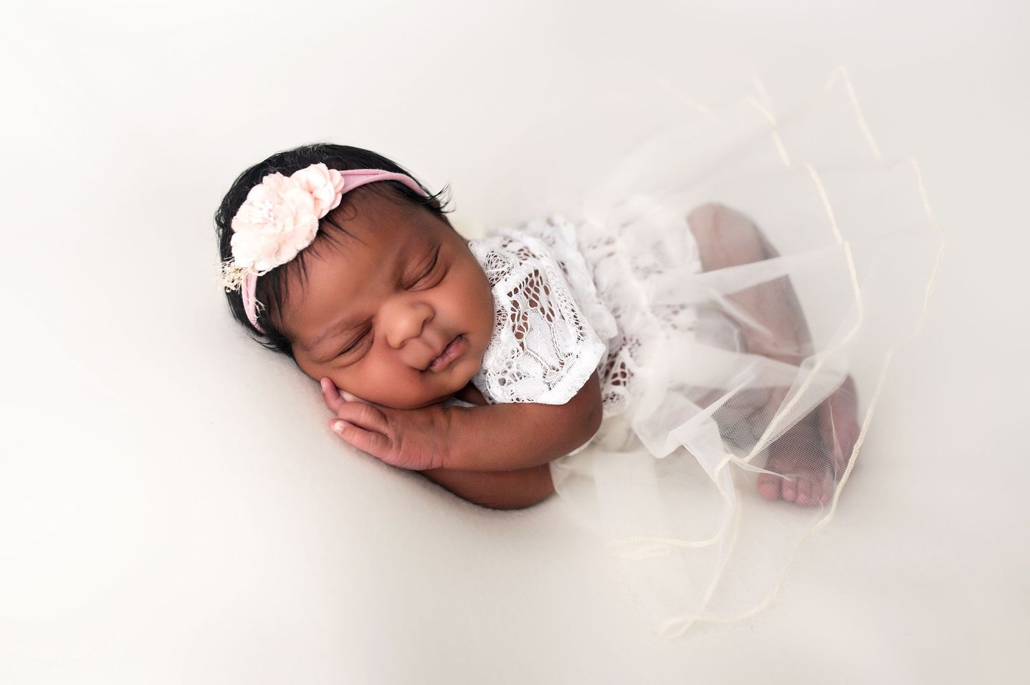 Artistic series of newborn baby in white swaddle on light background.
