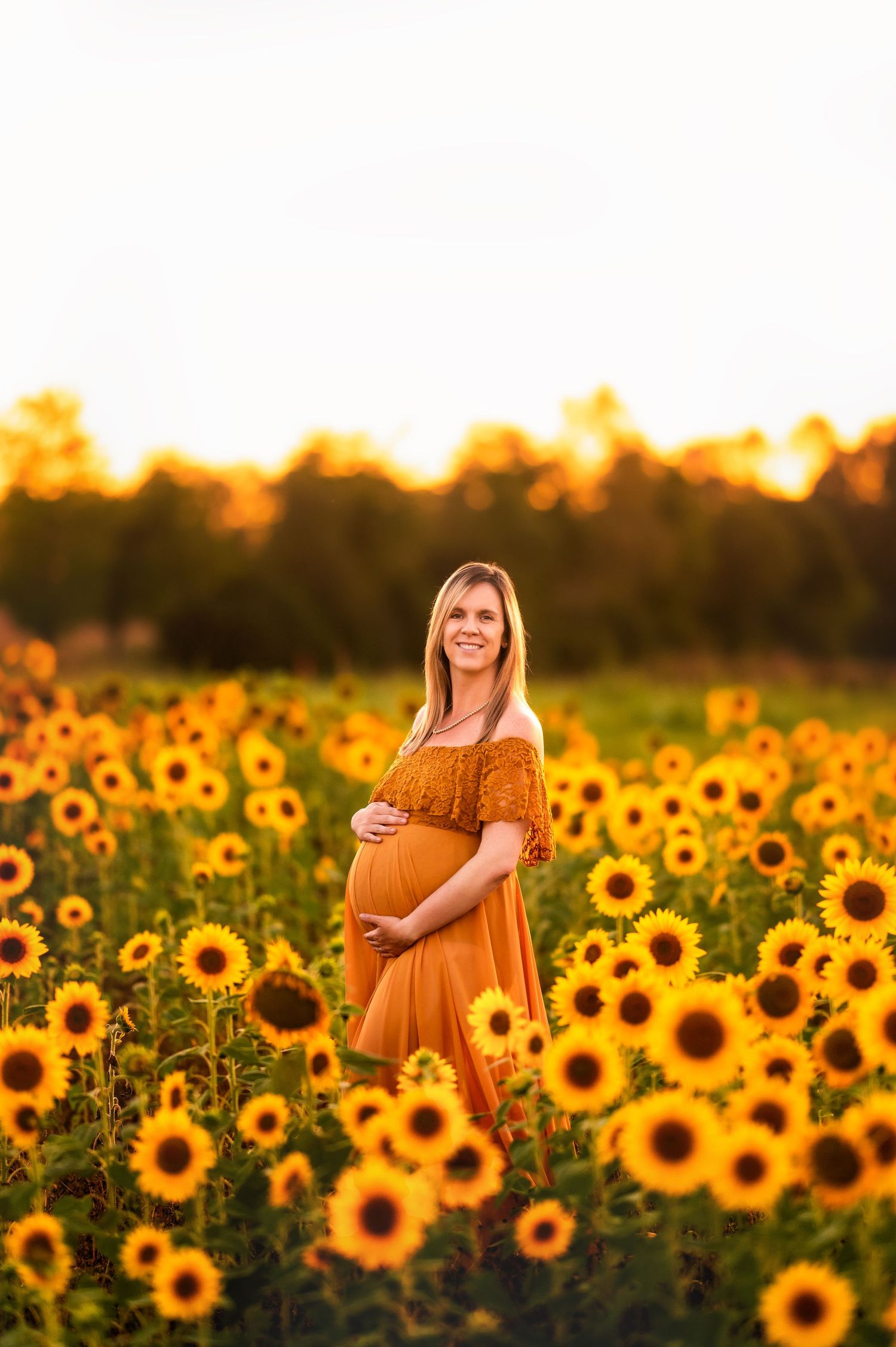 Stunning sunflower field maternity photos at golden hour sunset.