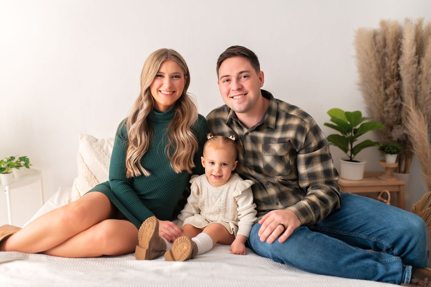 Family of three relaxing on floor during cozy home photography session.