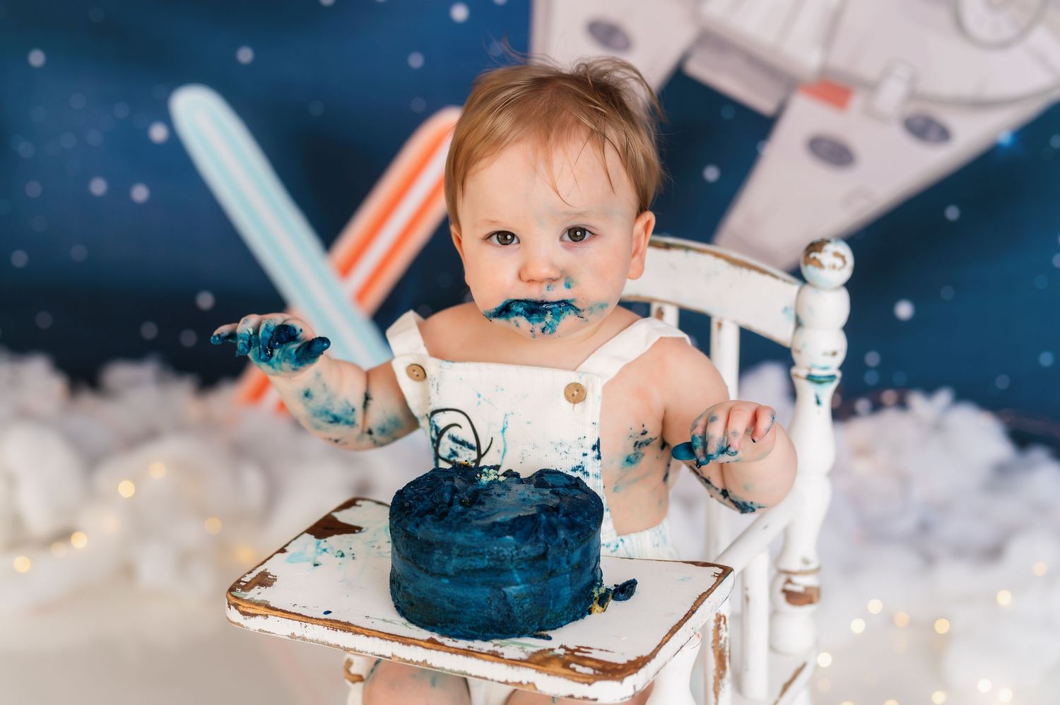 Star Wars themed first birthday photoshoot with starry backdrop and white cloud effects.