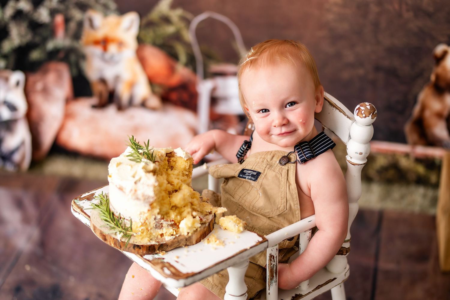 Rustic woodland birthday setup with fox decorations and white high chair.