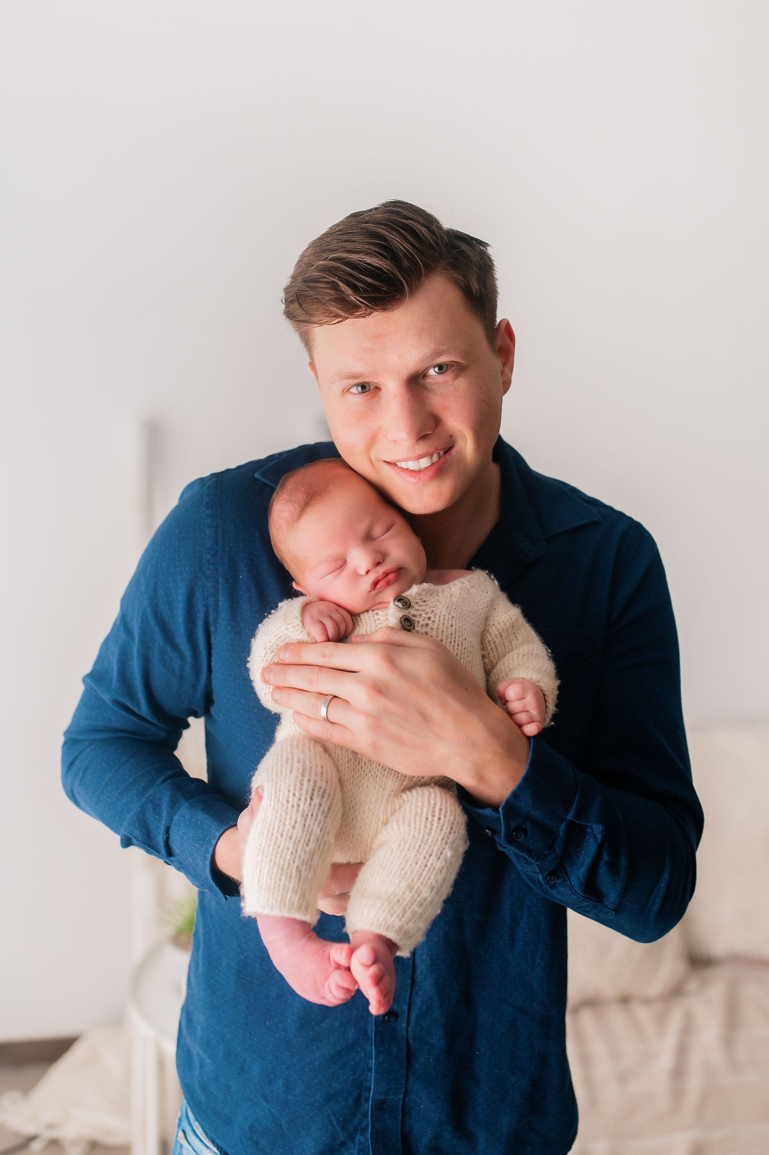 Progressive shots of person in blue shirt holding and bonding with newborn baby.