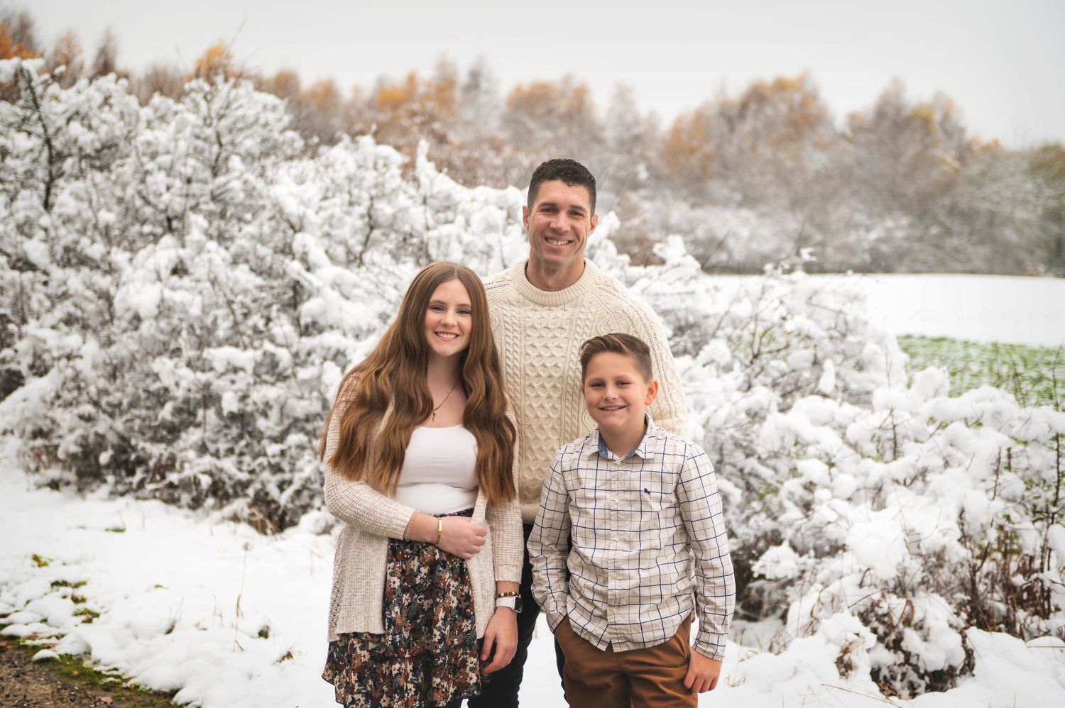 A casual engagement photo session in a snow-covered natural setting.