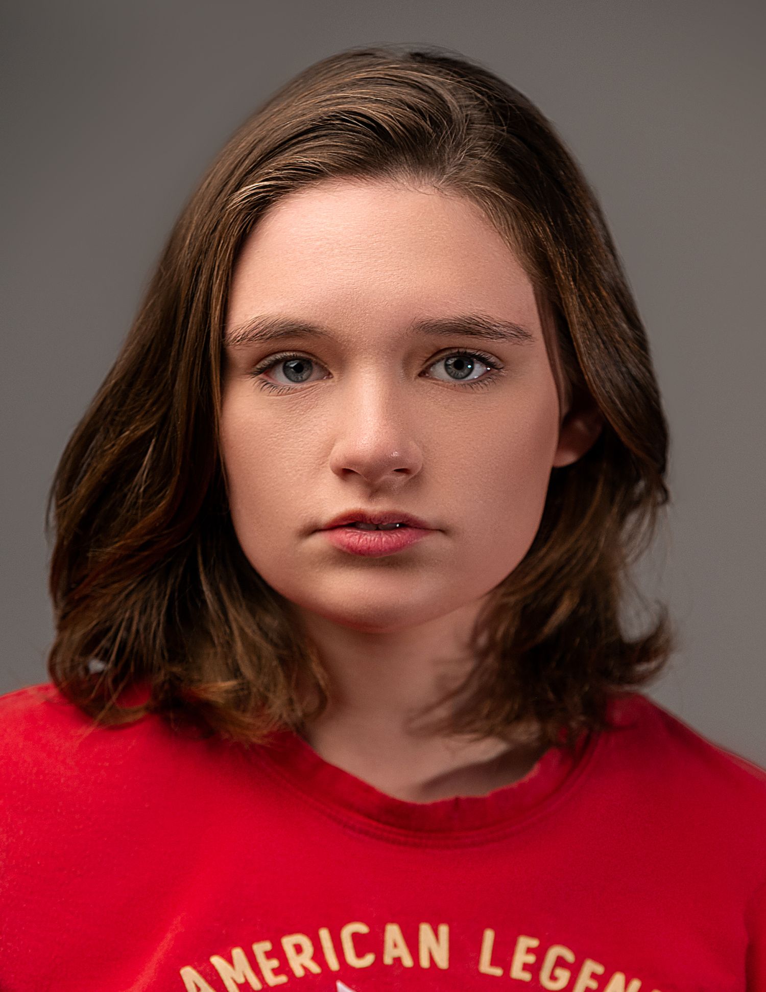 Close-up portrait sequence wearing a red sweater with American Legend text against gray background.