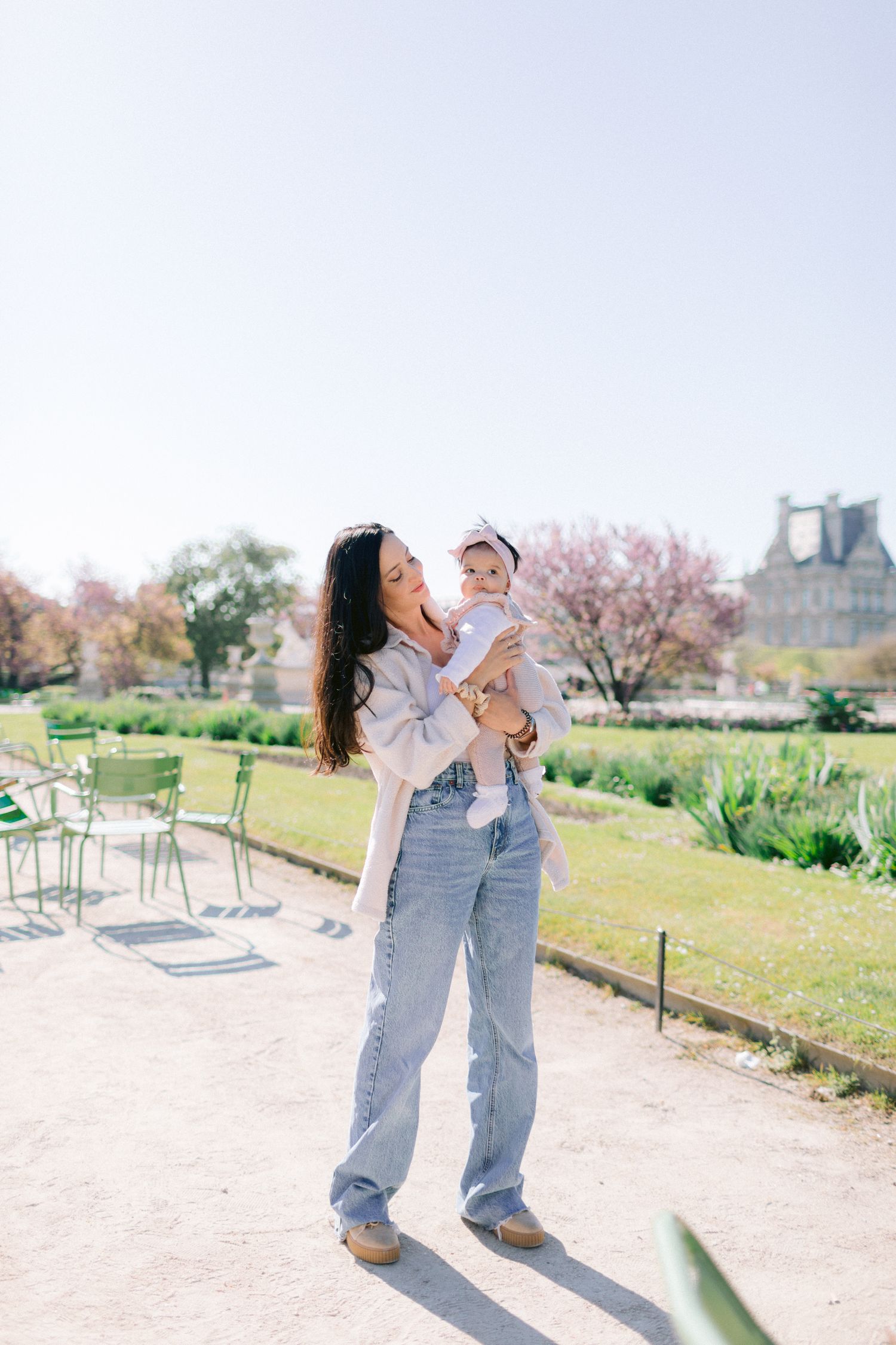 Couple in casual outfits enjoying a playful moment in a sunny outdoor park setting.