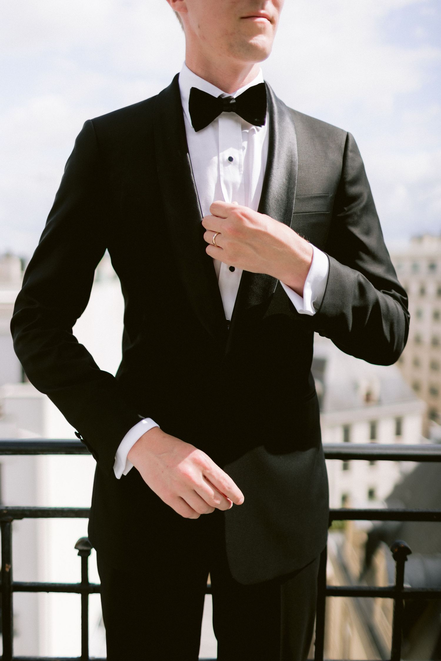 Elegant black tuxedo details captured during a rooftop wedding celebration.