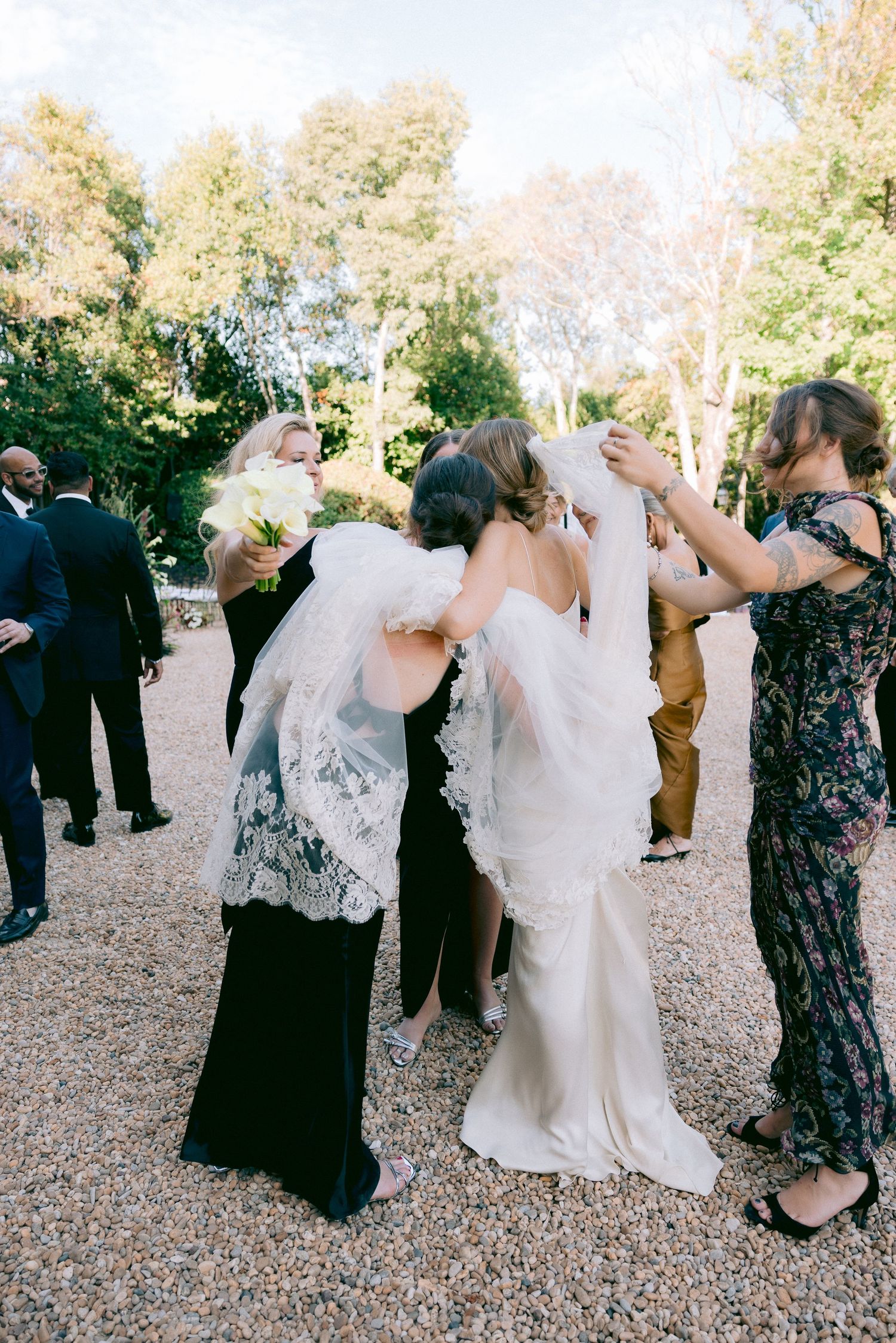 Wedding celebration with guests dancing and celebrating in outdoor courtyard.