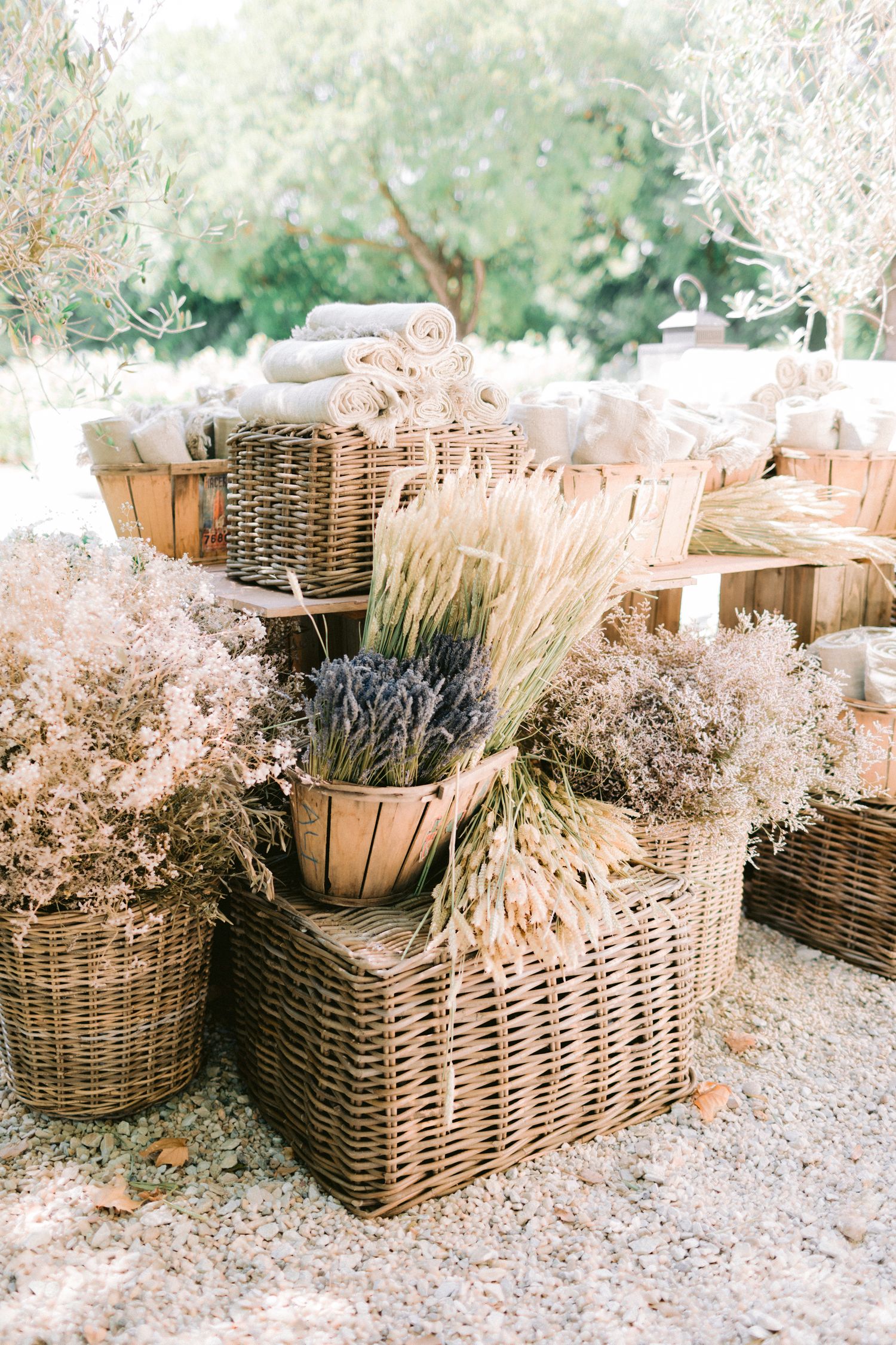 Rustic wicker baskets filled with dried flowers and grasses arranged outdoors.