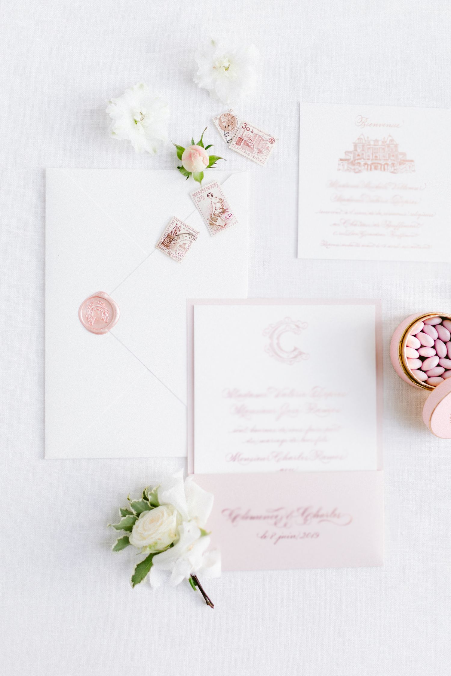 Elegant wedding stationery in soft pink and white with floral accents.