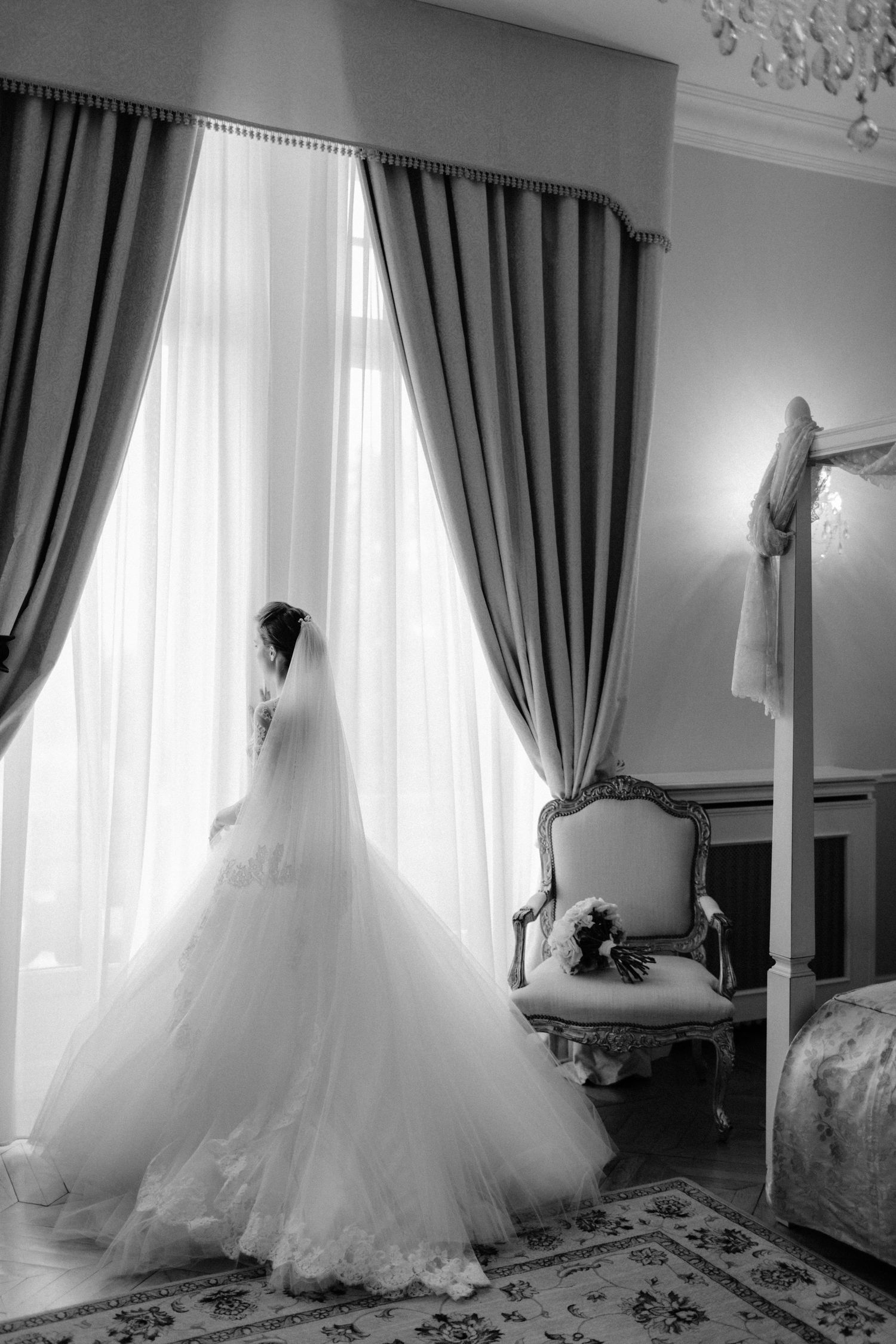Dramatic black and white photos of a flowing wedding dress train in an elegant room.
