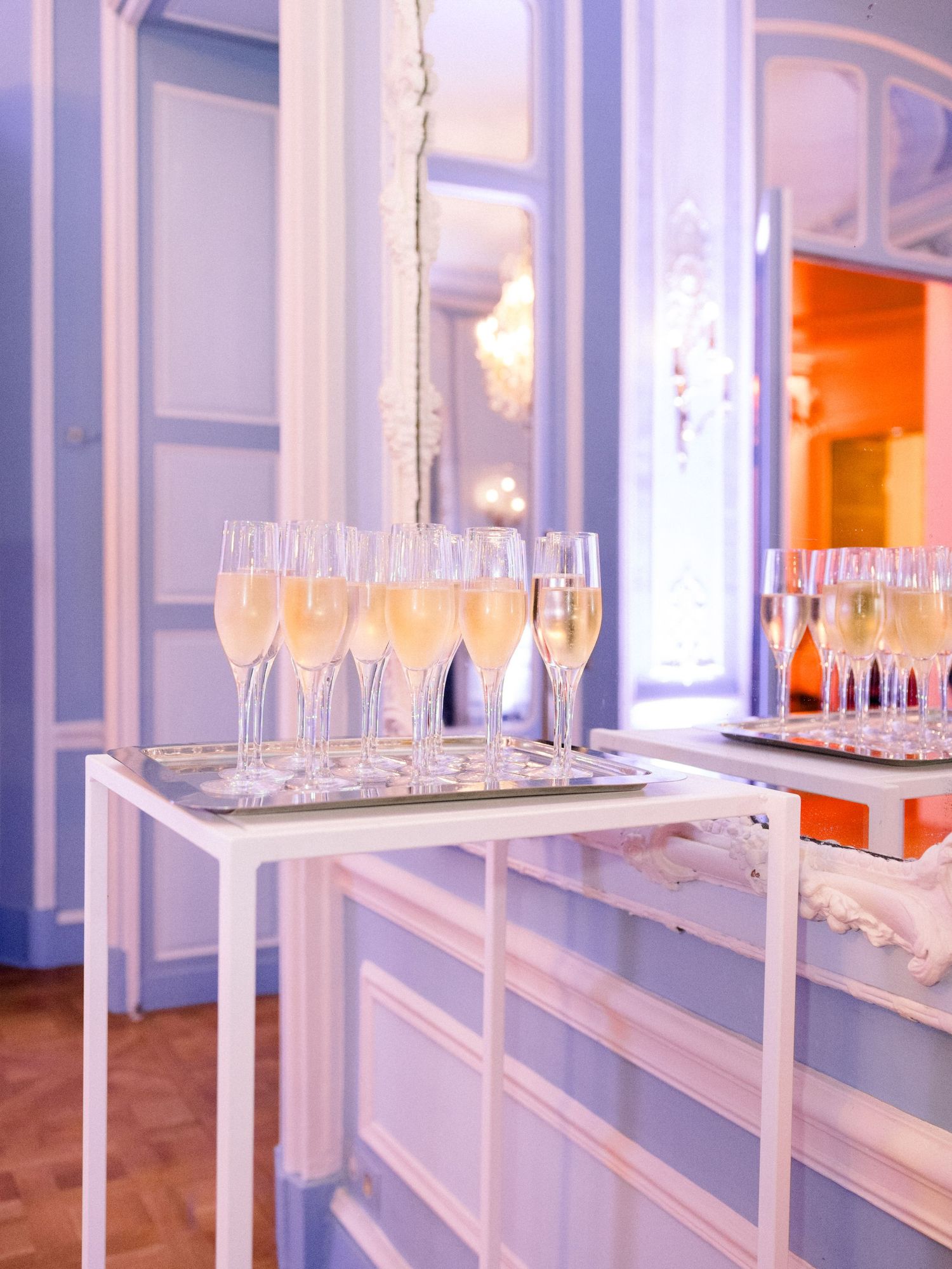 Modern white shelving displays rows of clear glassware for an elegant wedding reception.