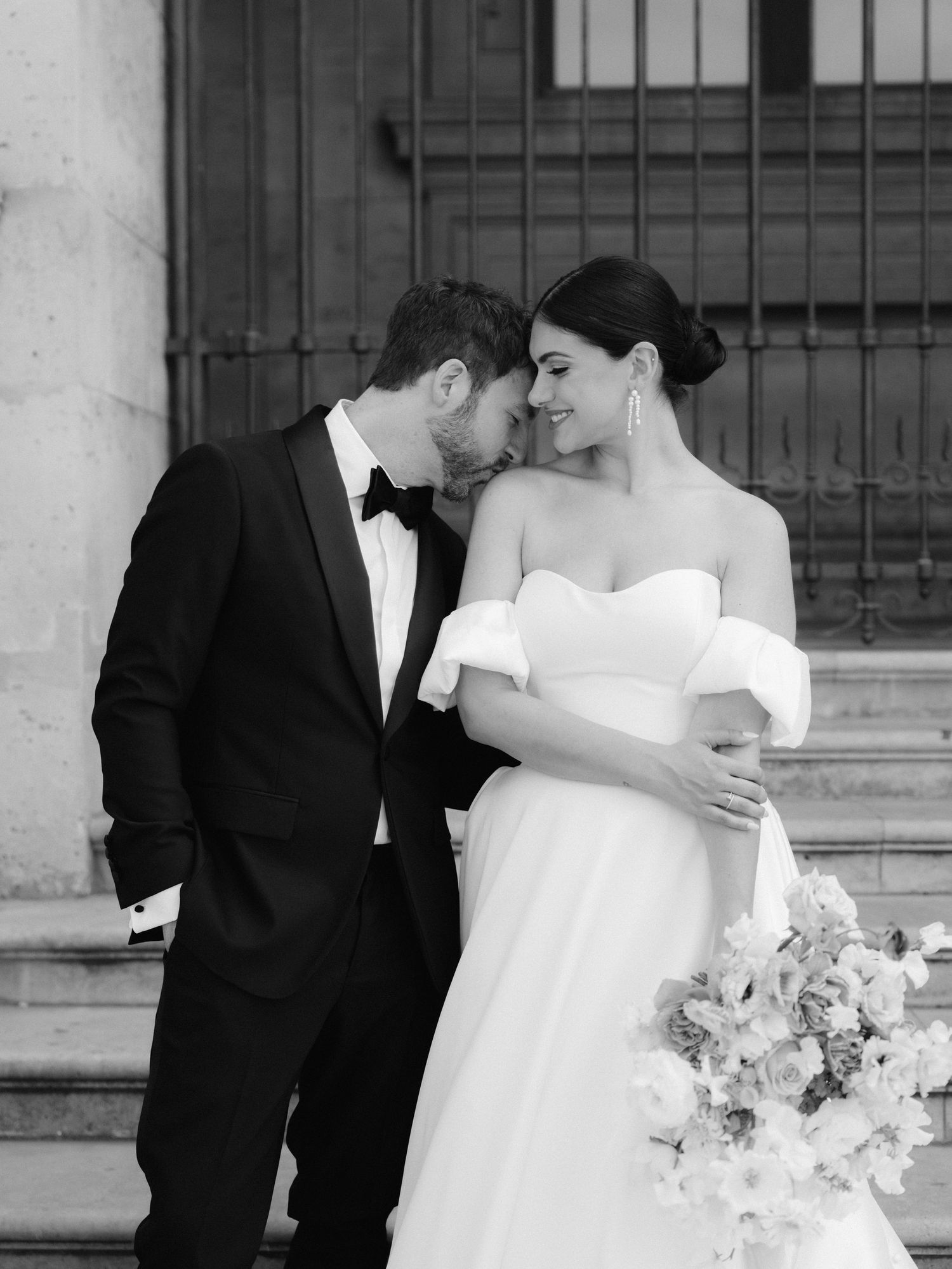Classic black and white wedding portrait with elegant floral bouquet.