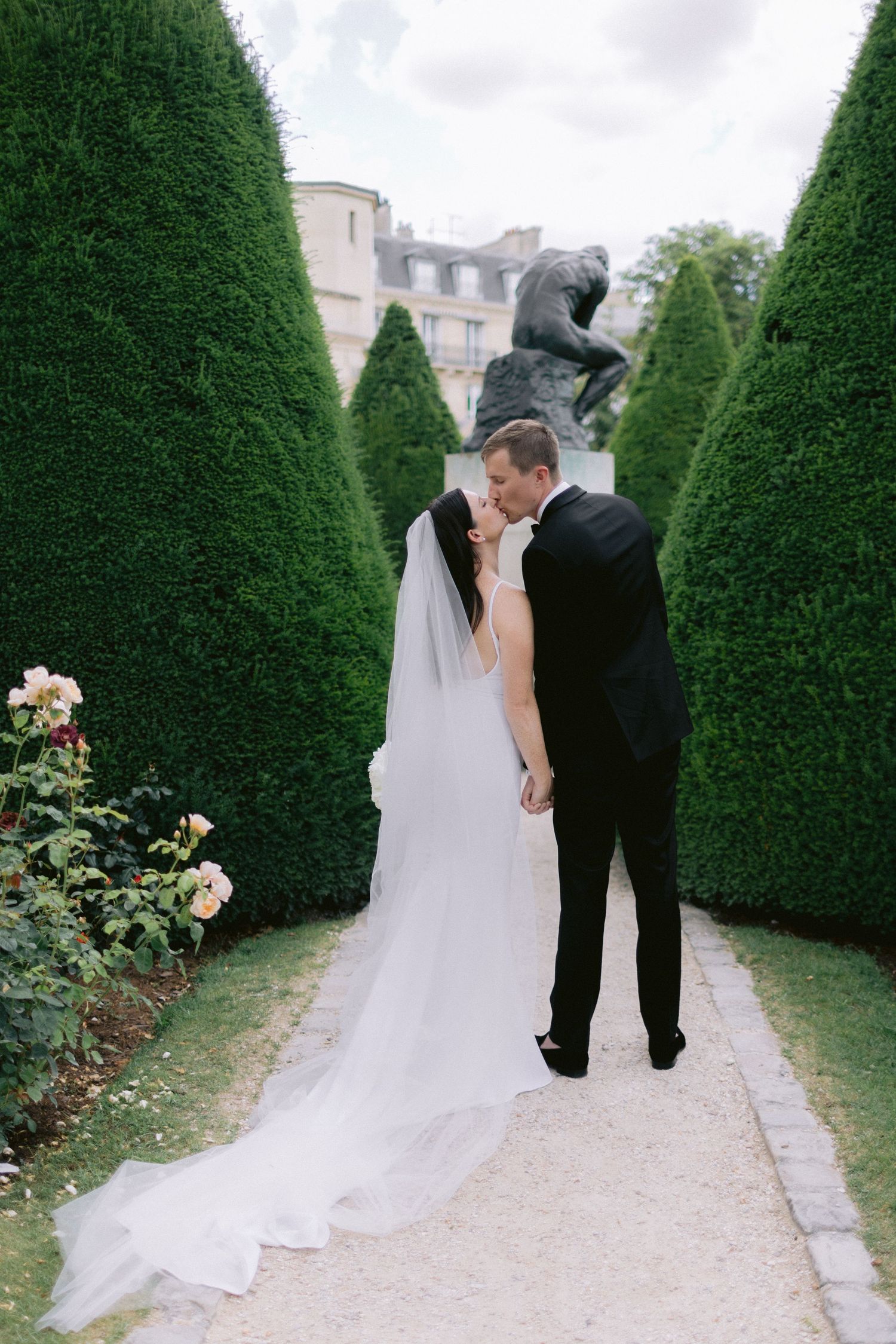 Bride and groom kissing during an intimate Paris elopement at the Musée Rodin, photographed in a refined and timeless style.